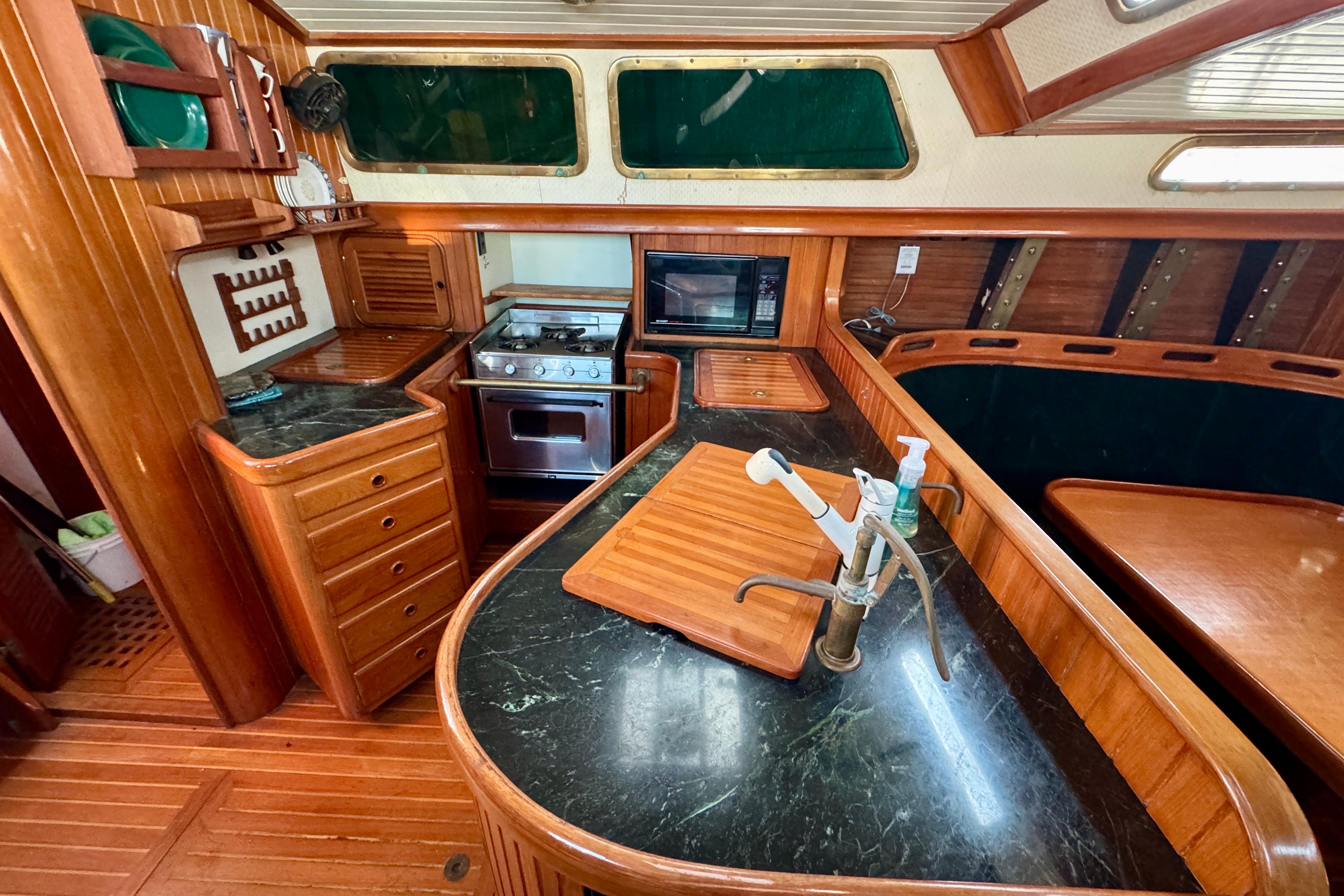 Luxurious 1988 Hans Christian Christina yacht kitchen with wood cabinetry and modern appliances.