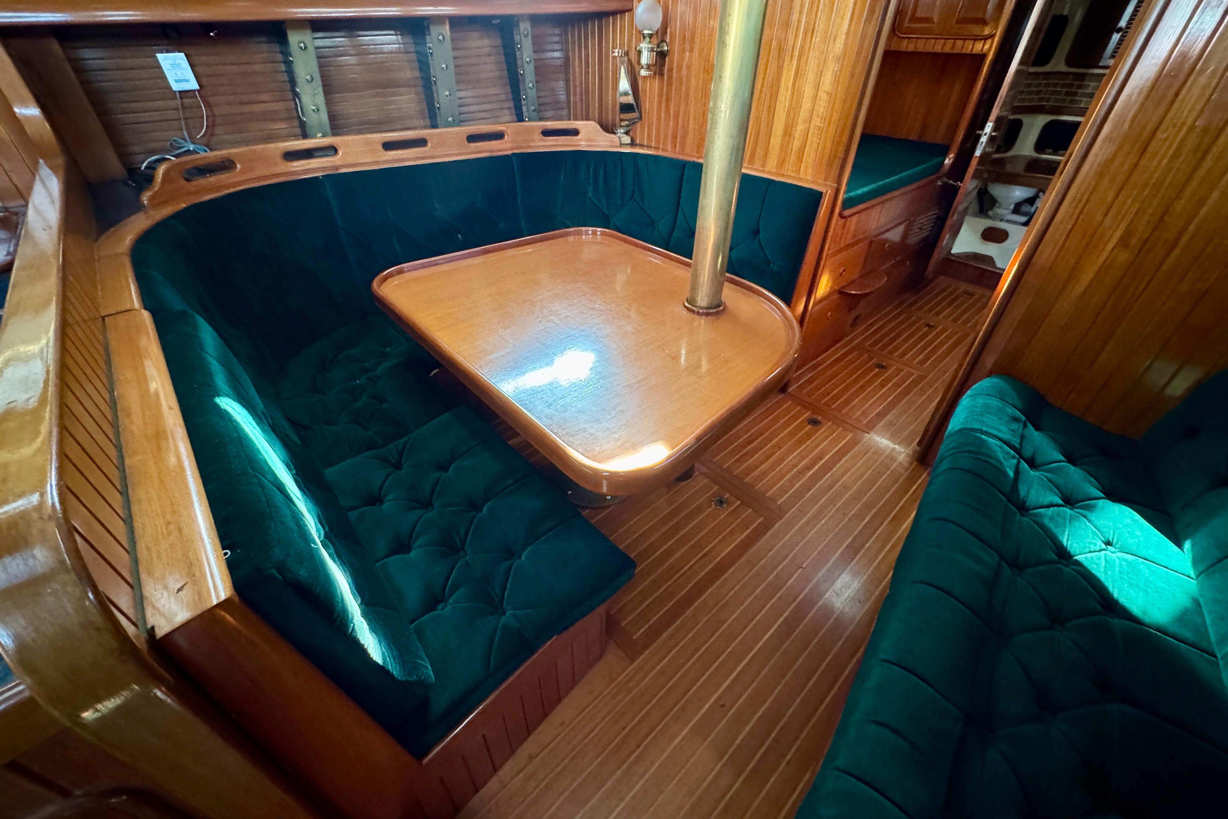 Luxurious 1988 Hans Christian Christina yacht interior with elegant wood and plush seating.