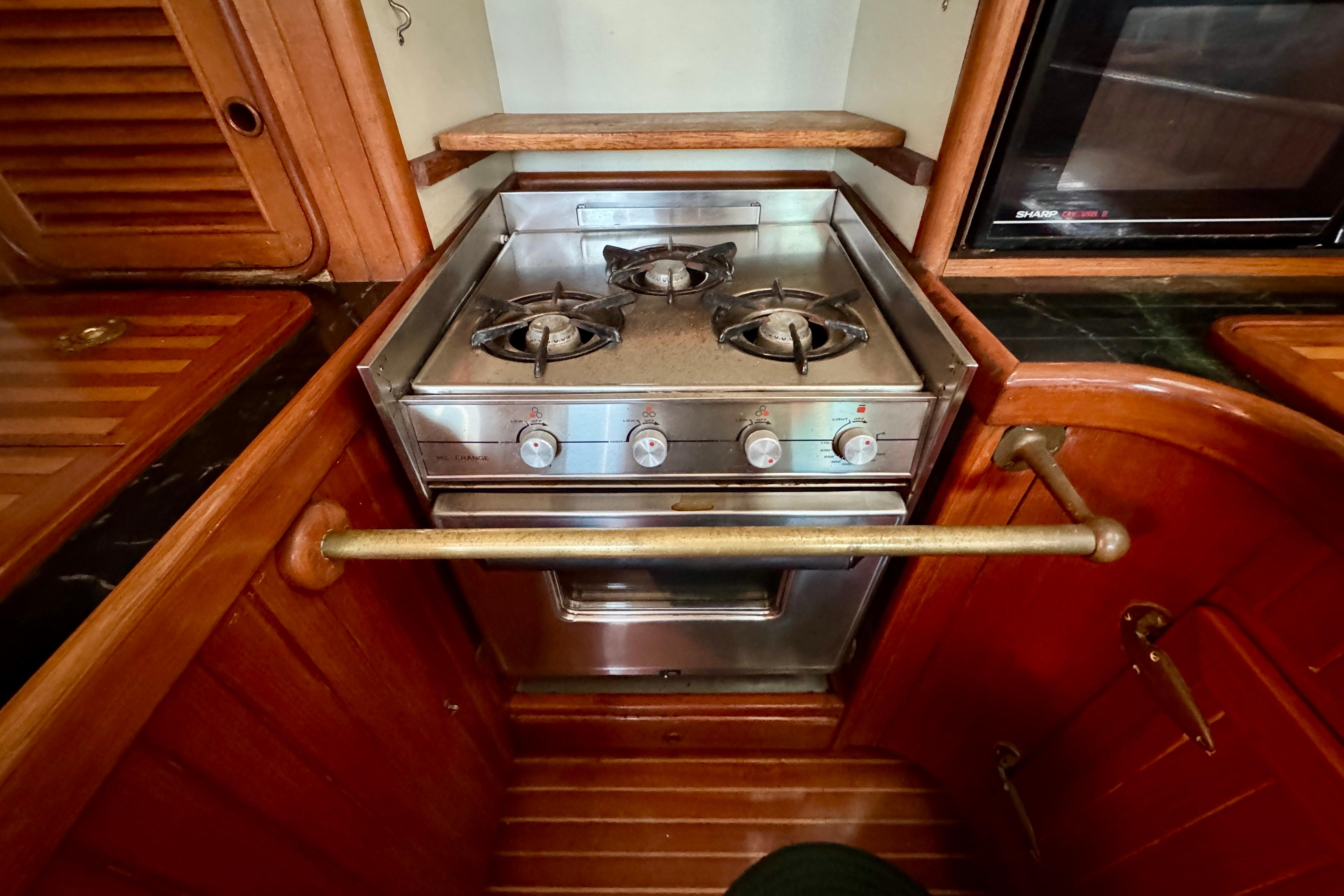 Compact kitchen stove in a 1988 Hans Christian Christina yacht, featuring three burners.