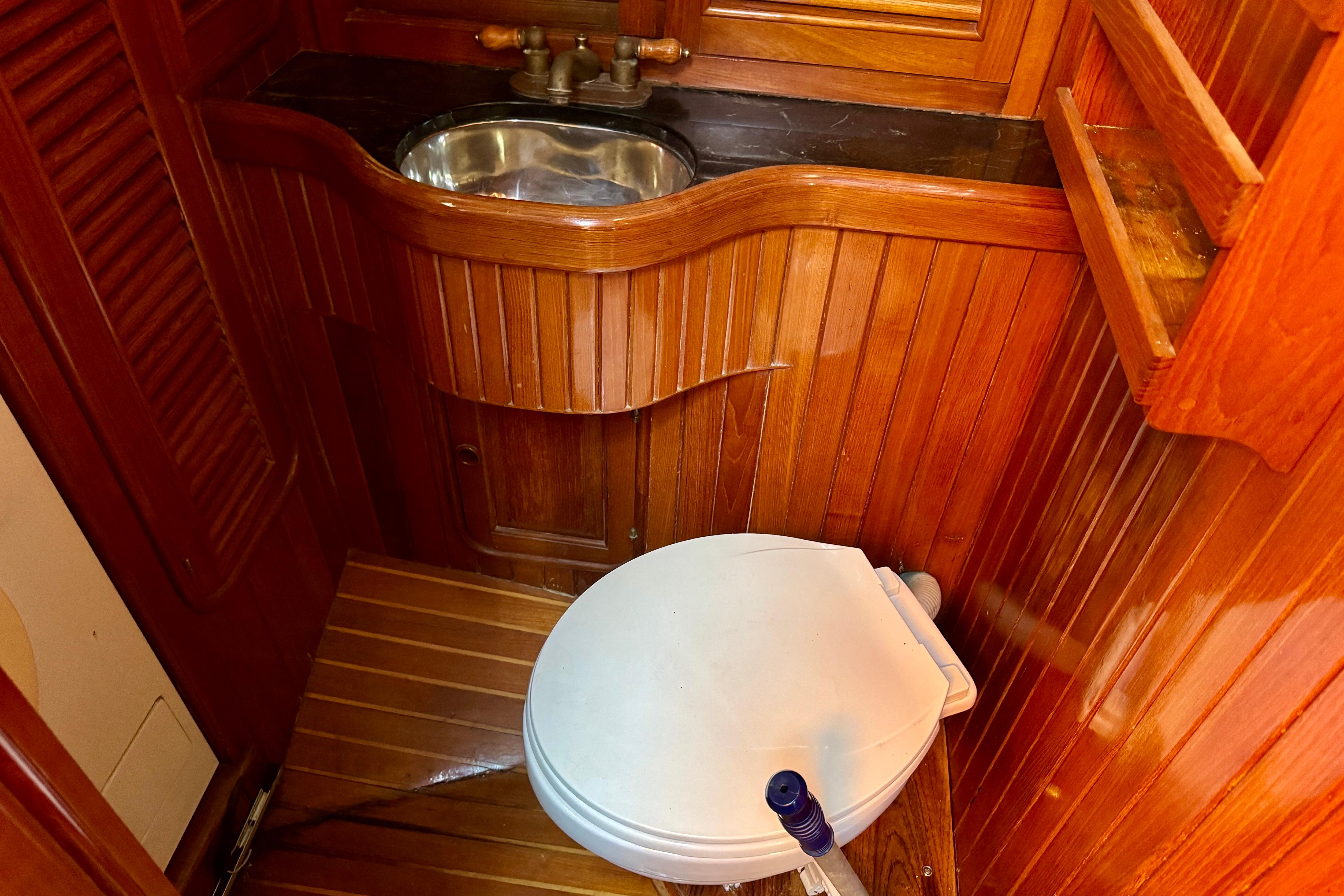 Wood-paneled boat bathroom with sink and toilet, Hans Christian Christina 1988 model.