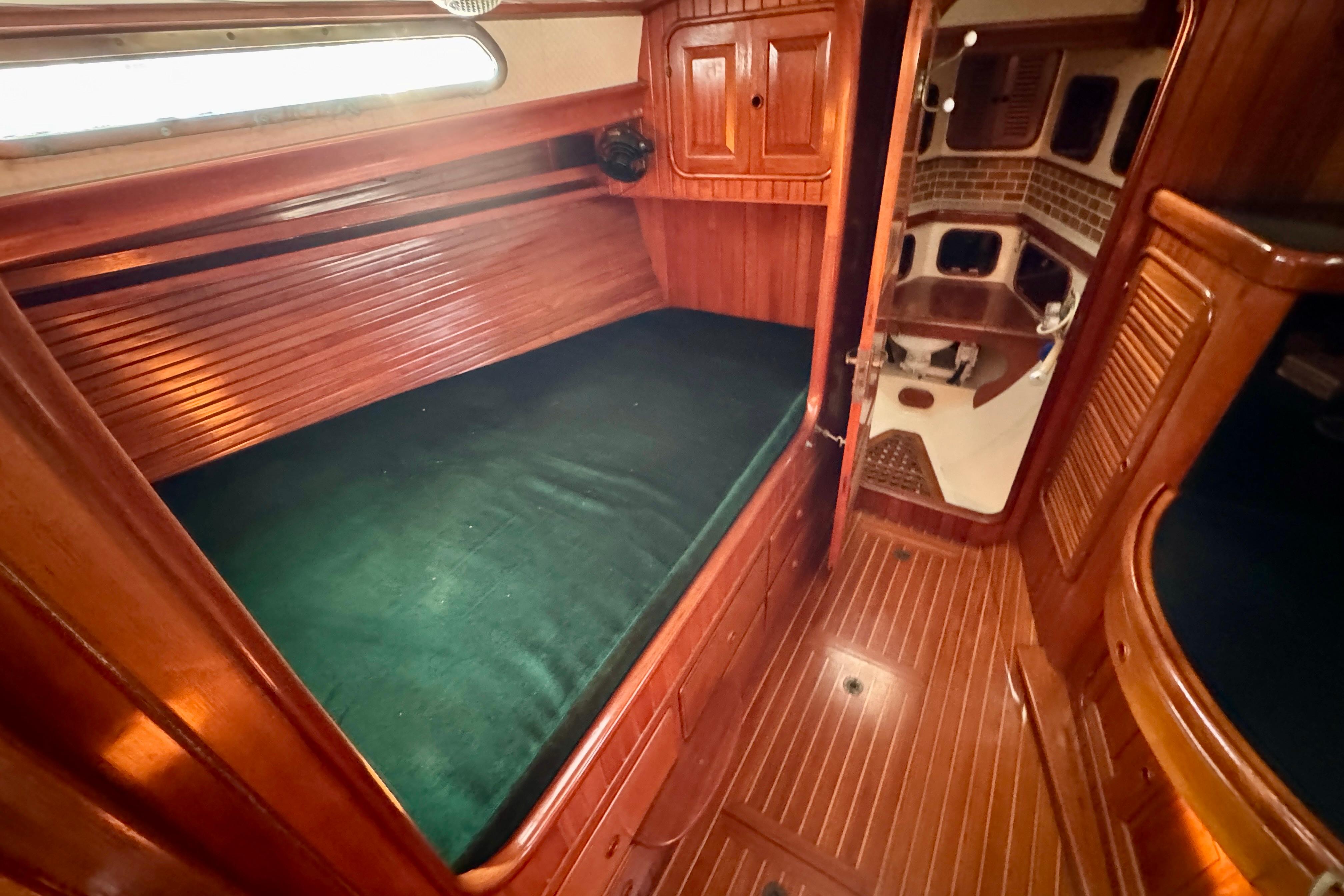 Luxurious 1988 Hans Christian Christina yacht interior with wooden finish and cozy sleeping area.