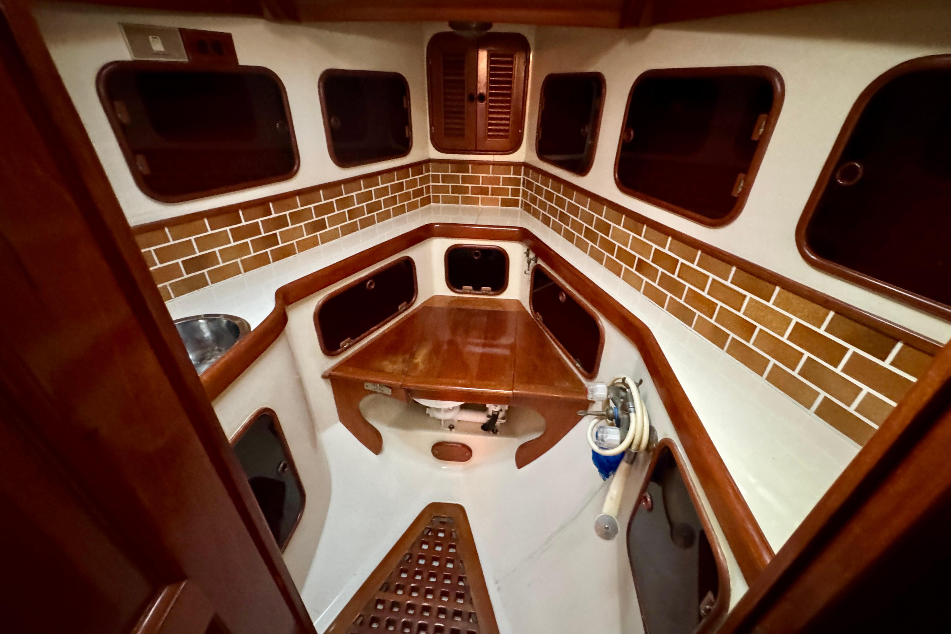 Interior of 1988 Hans Christian Christina sailboat with wooden cabinetry and tiled walls.