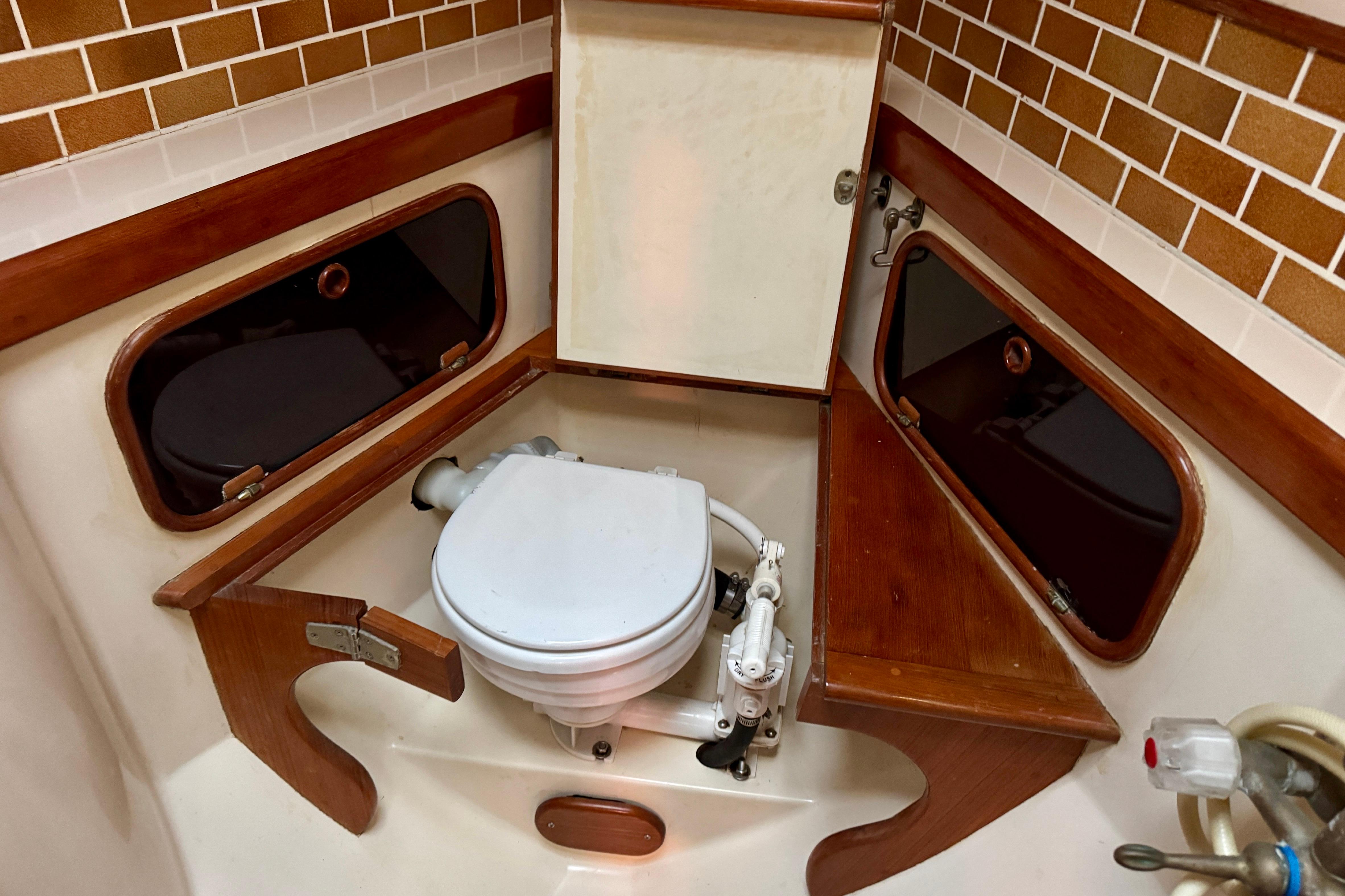 1988 Hans Christian Christina boat bathroom with wooden accents and marine toilet.