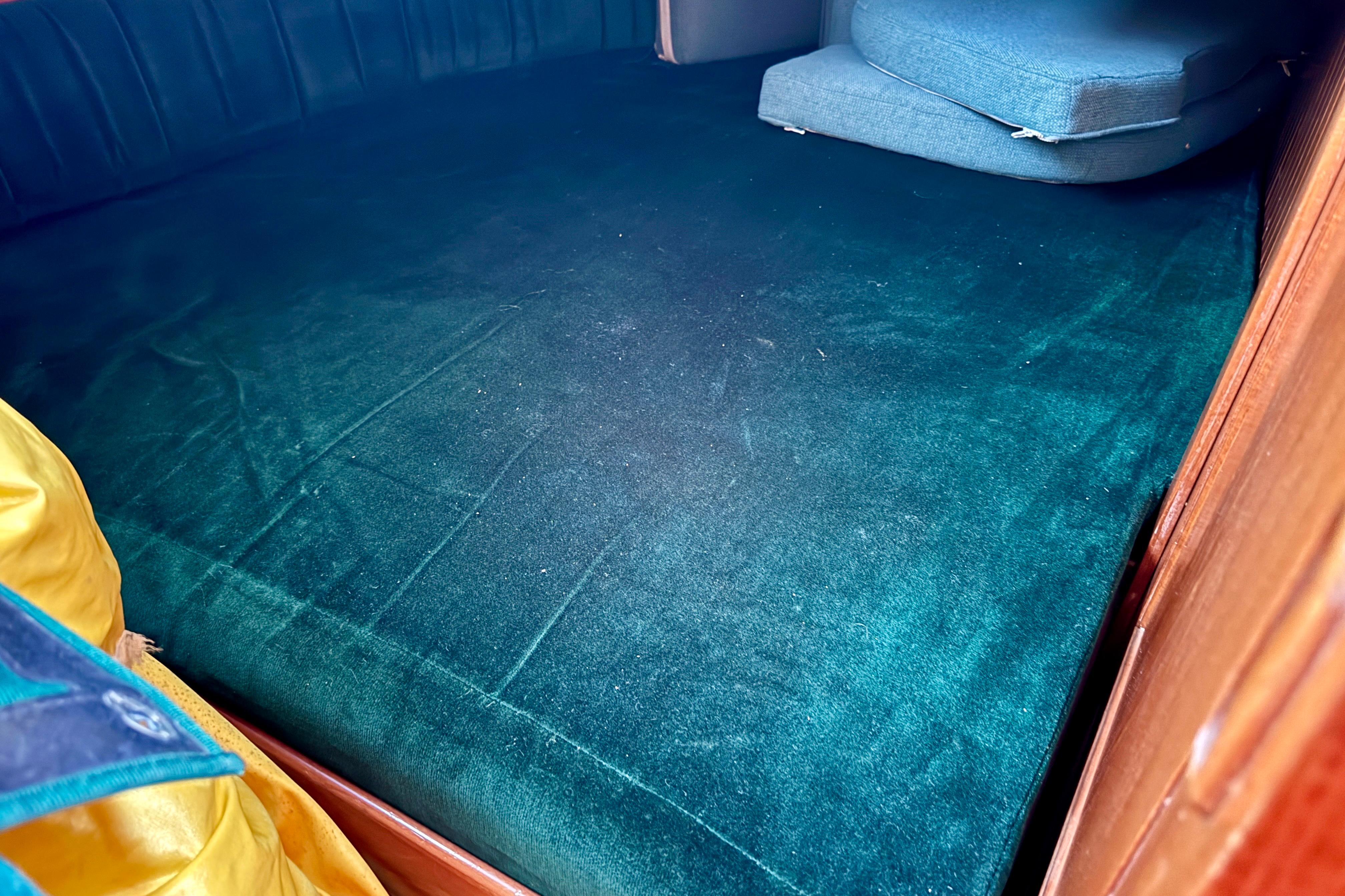 Interior cabin of 1988 Hans Christian Christina with green upholstery and cushions.