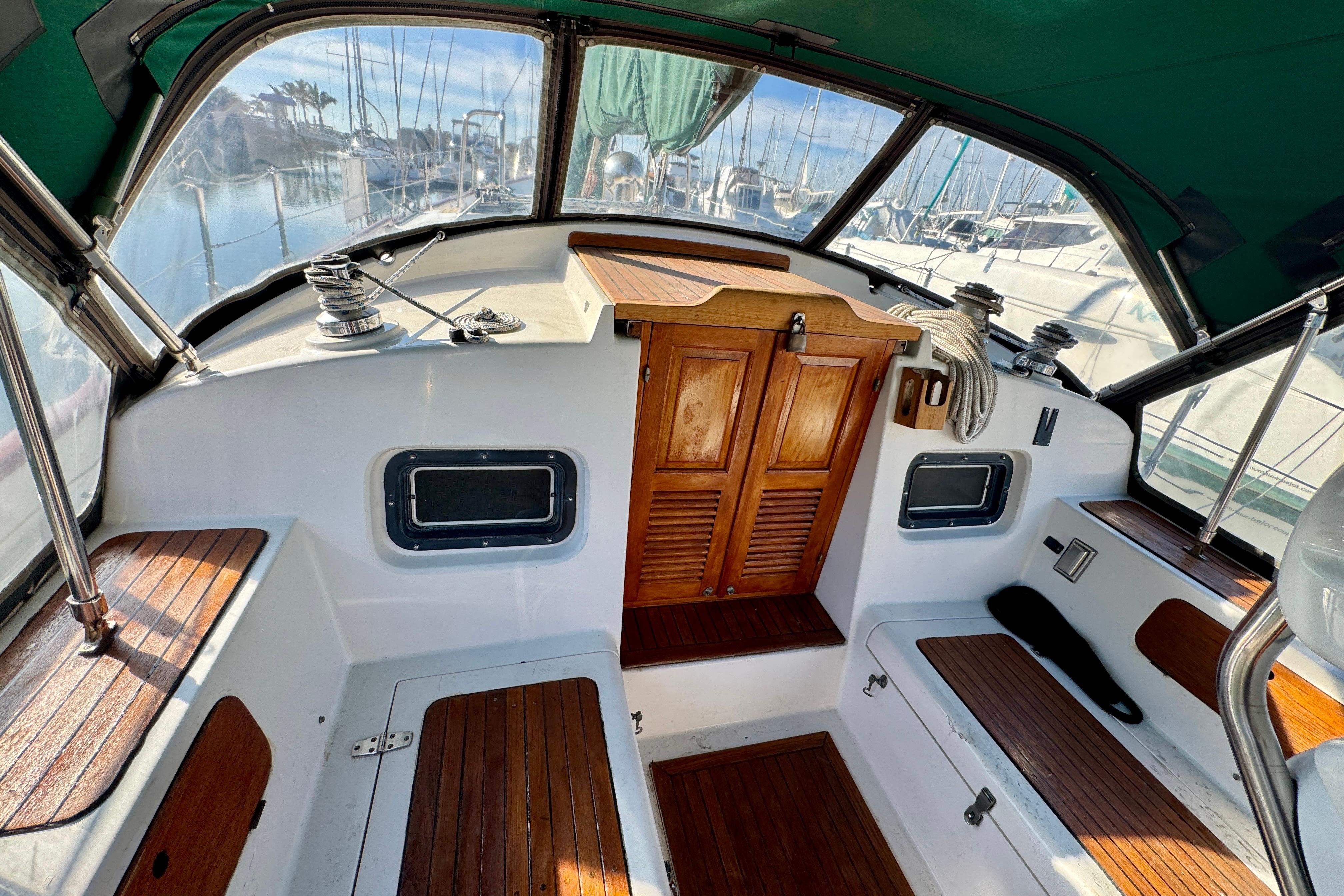 Cockpit of 1988 Hans Christian Christina sailboat with wooden accents and marina view.