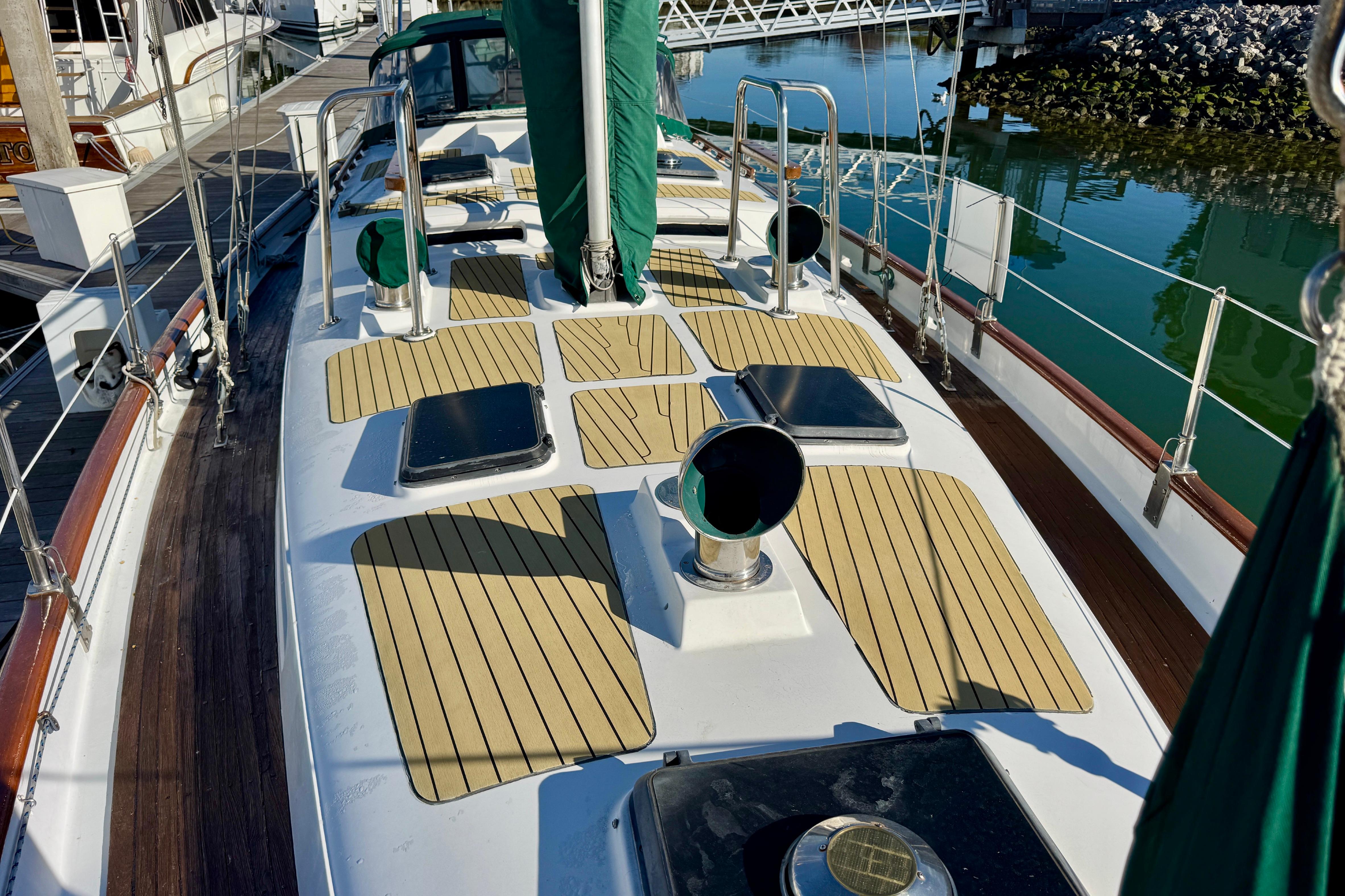 1988 Hans Christian Christina yacht deck with wooden accents, docked in a marina.