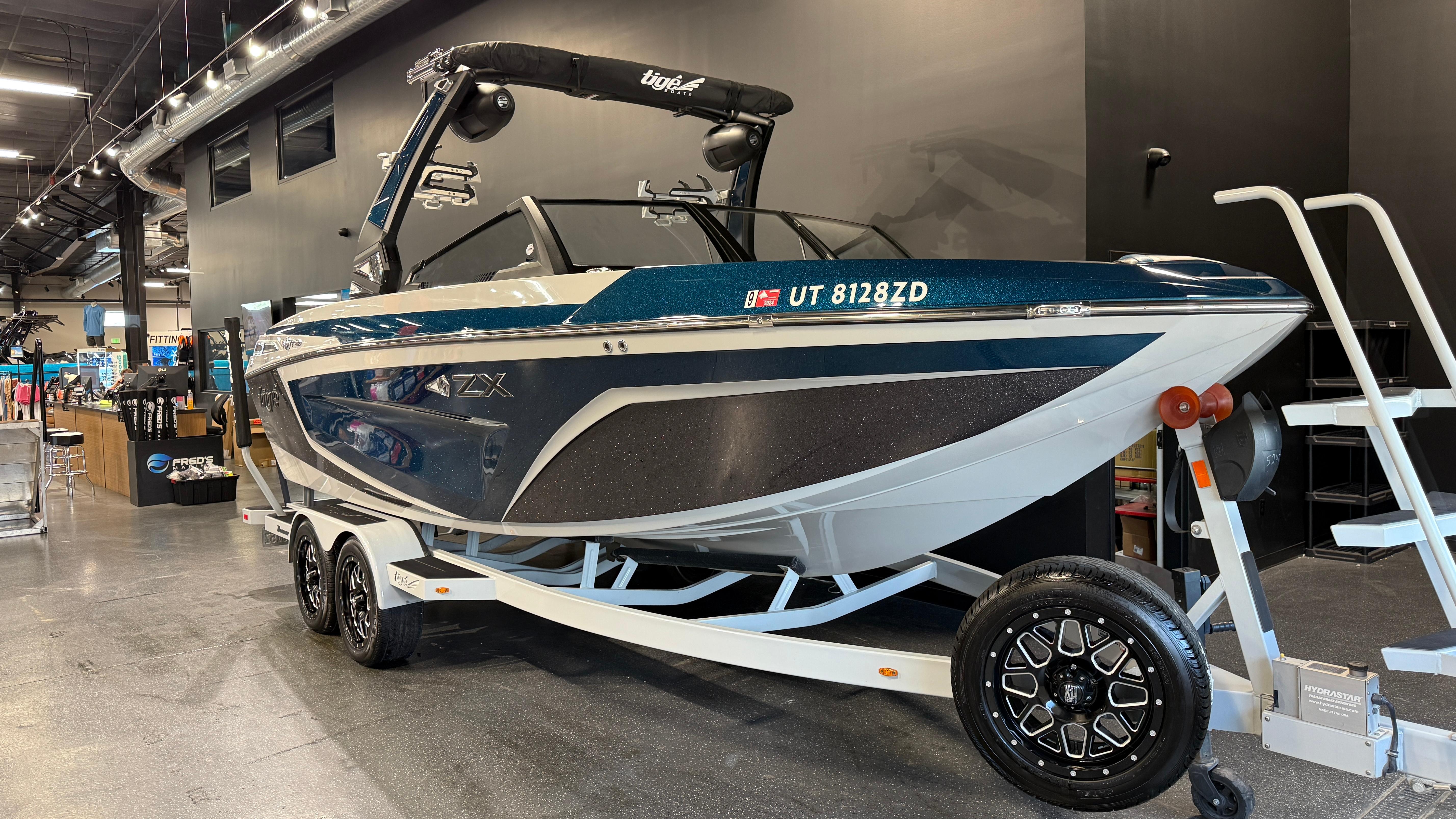 2022 Tigé 23ZX boat on trailer in showroom, featuring sleek design and modern features.
