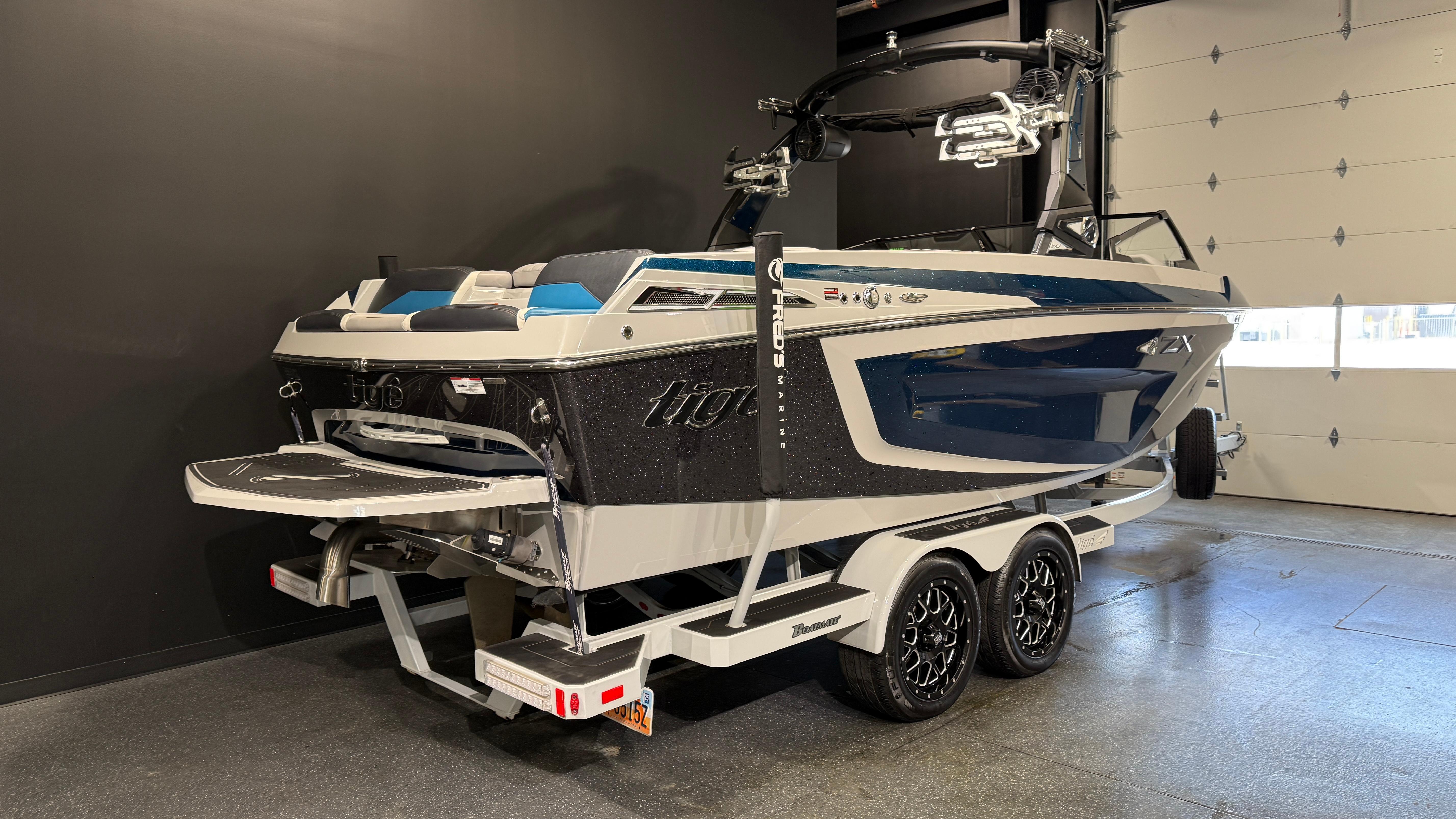 2022 Tigé 23ZX boat on trailer in showroom, featuring sleek design and modern features.