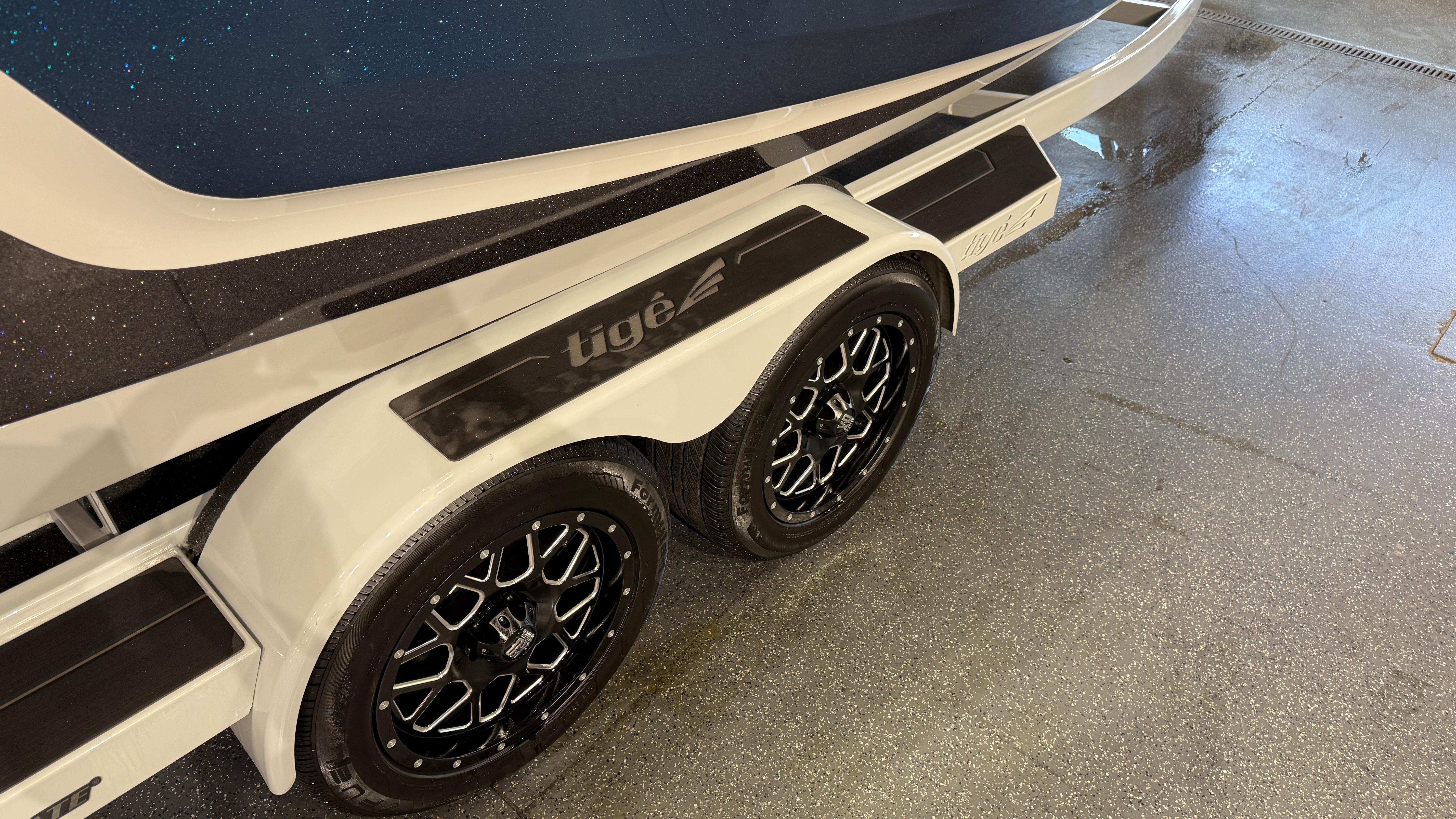 2022 Tigé 23ZX boat trailer with dual black alloy wheels.