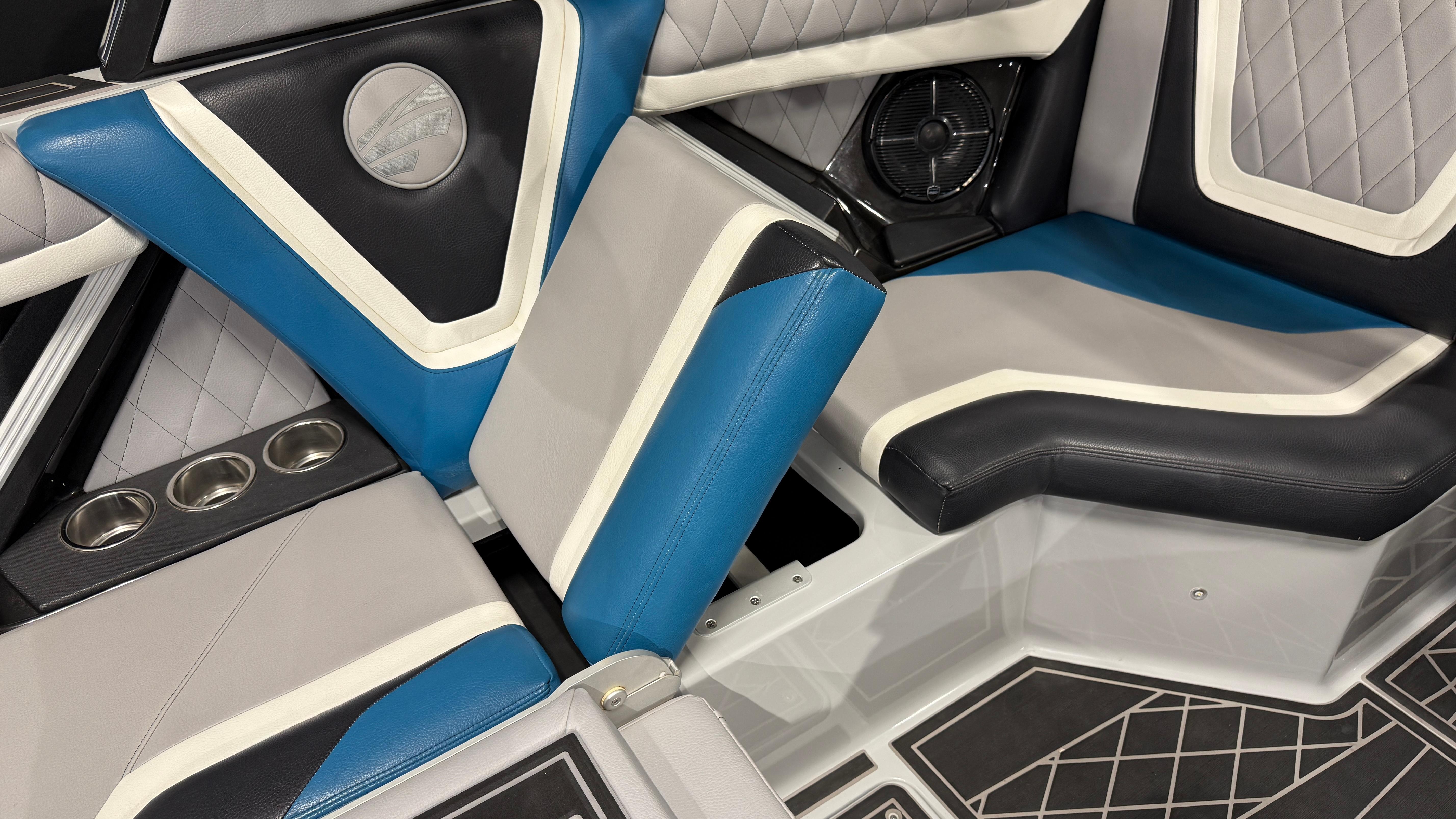 2022 Tigé 23ZX boat interior with blue and gray seating, cup holders, and speaker.