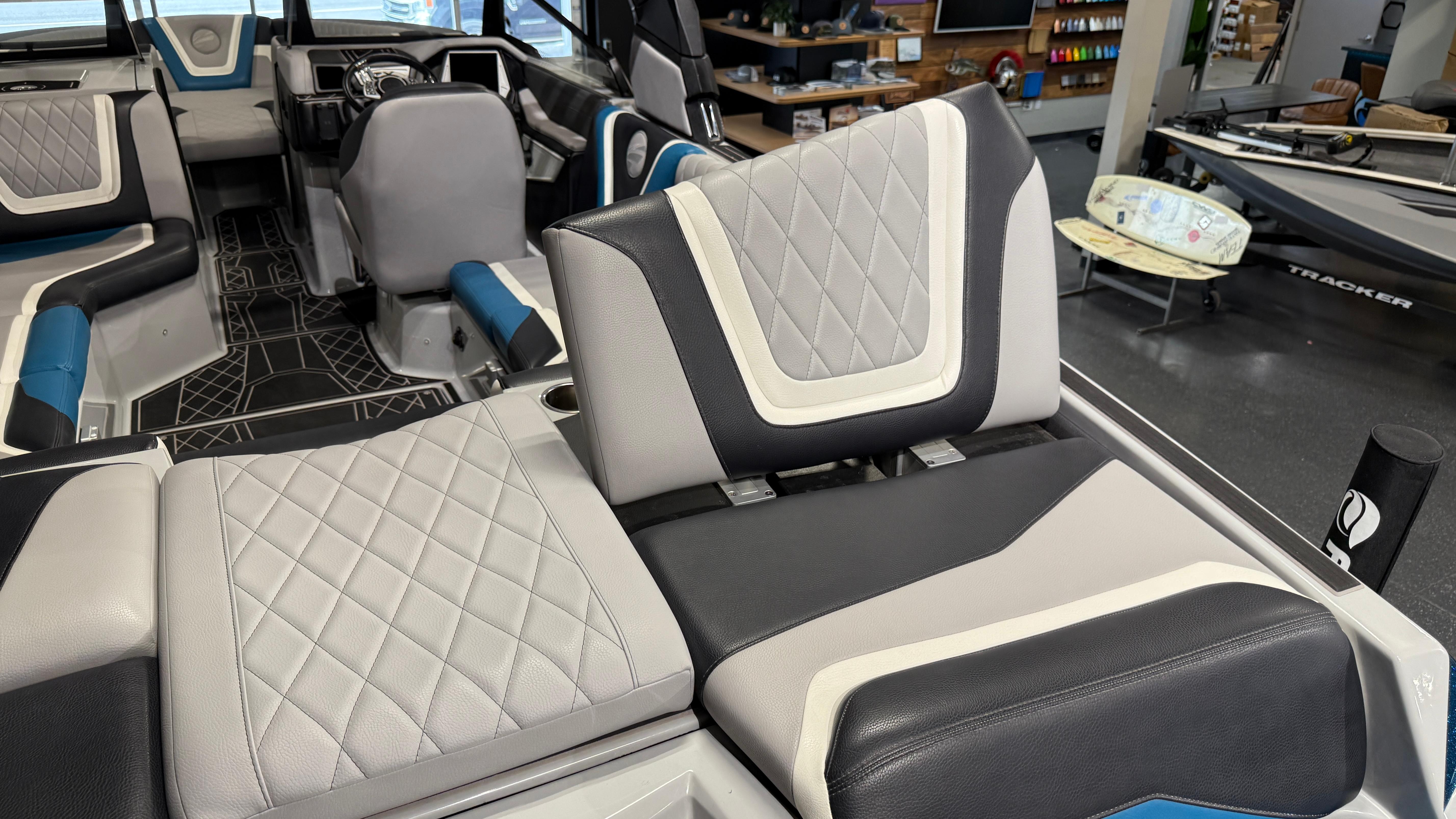 2022 Tigé 23ZX boat interior with stylish, diamond-stitched seating in a showroom setting.