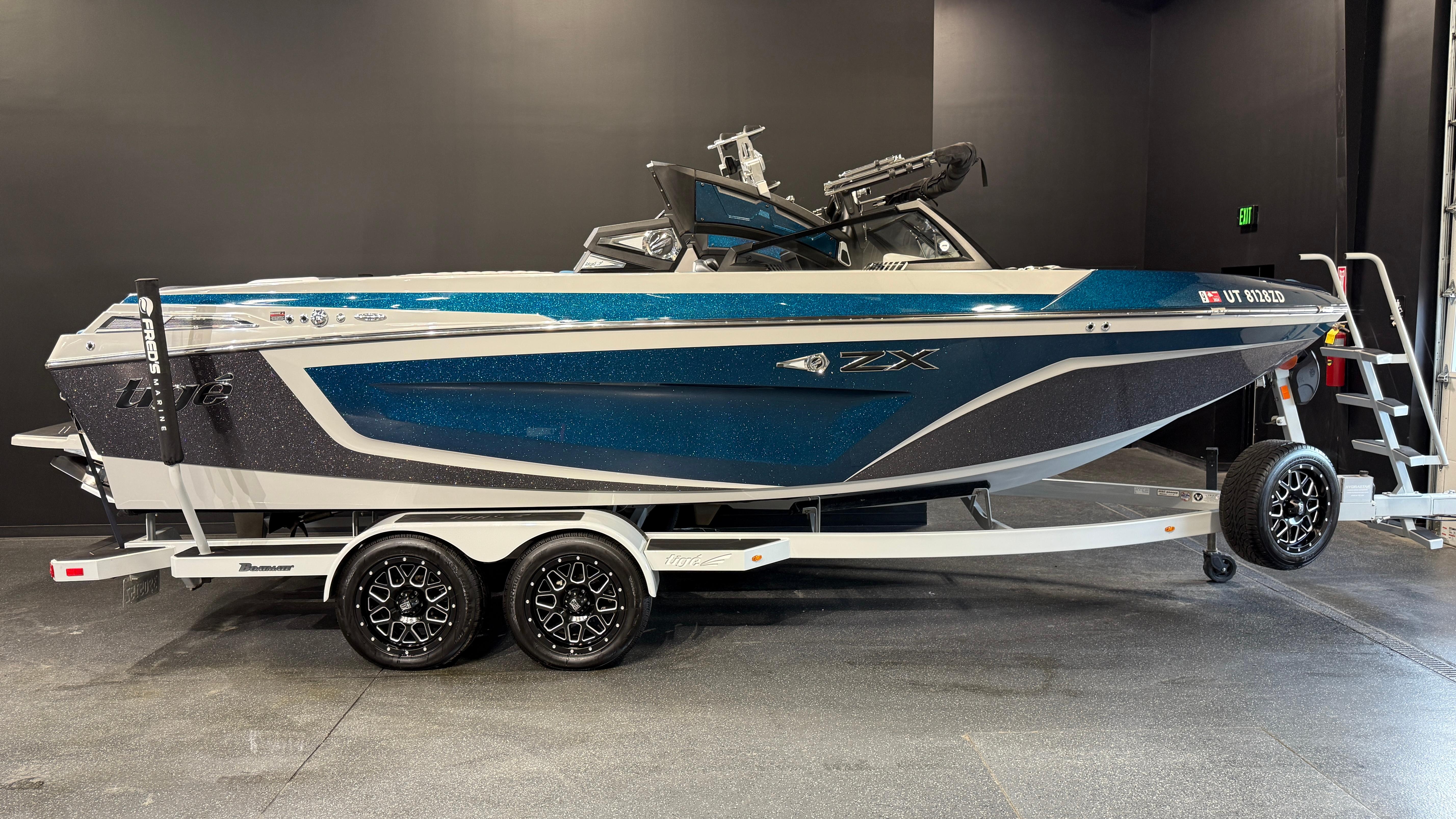 2022 Tigé 23ZX boat on trailer, blue and gray design, displayed indoors.