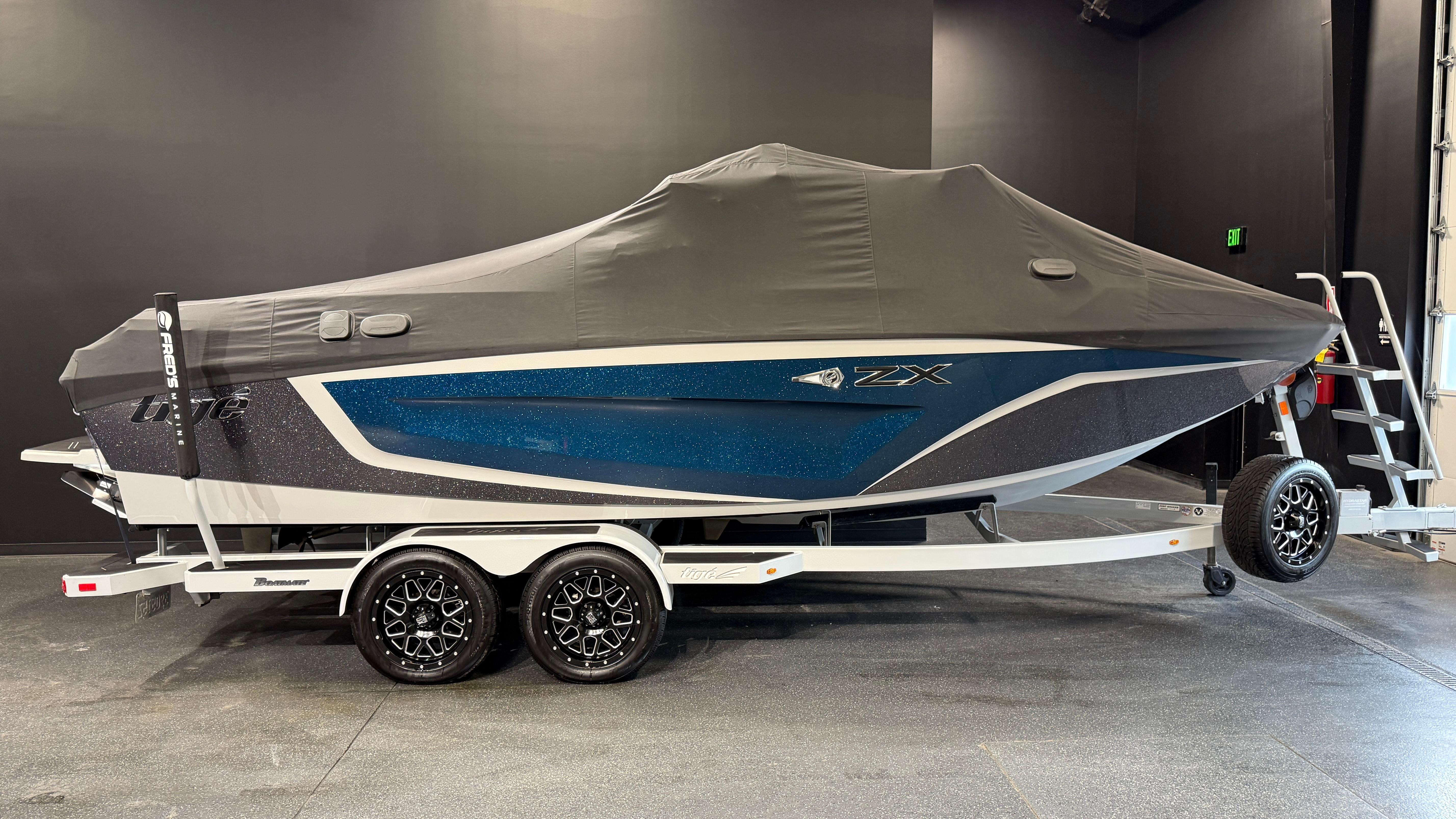 2022 Tigé 23ZX boat with cover on trailer in showroom.
