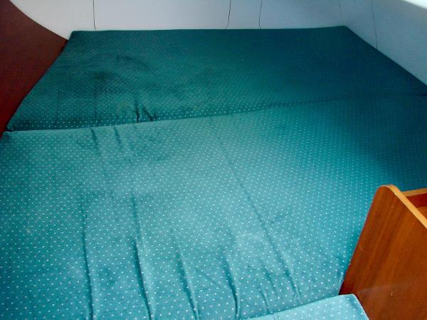 Interior of a 2001 Beneteau 331 yacht with green bedding.