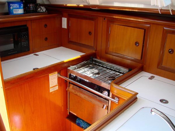 Beneteau 331 yacht kitchen, 2001 model, featuring wood cabinets and stove.