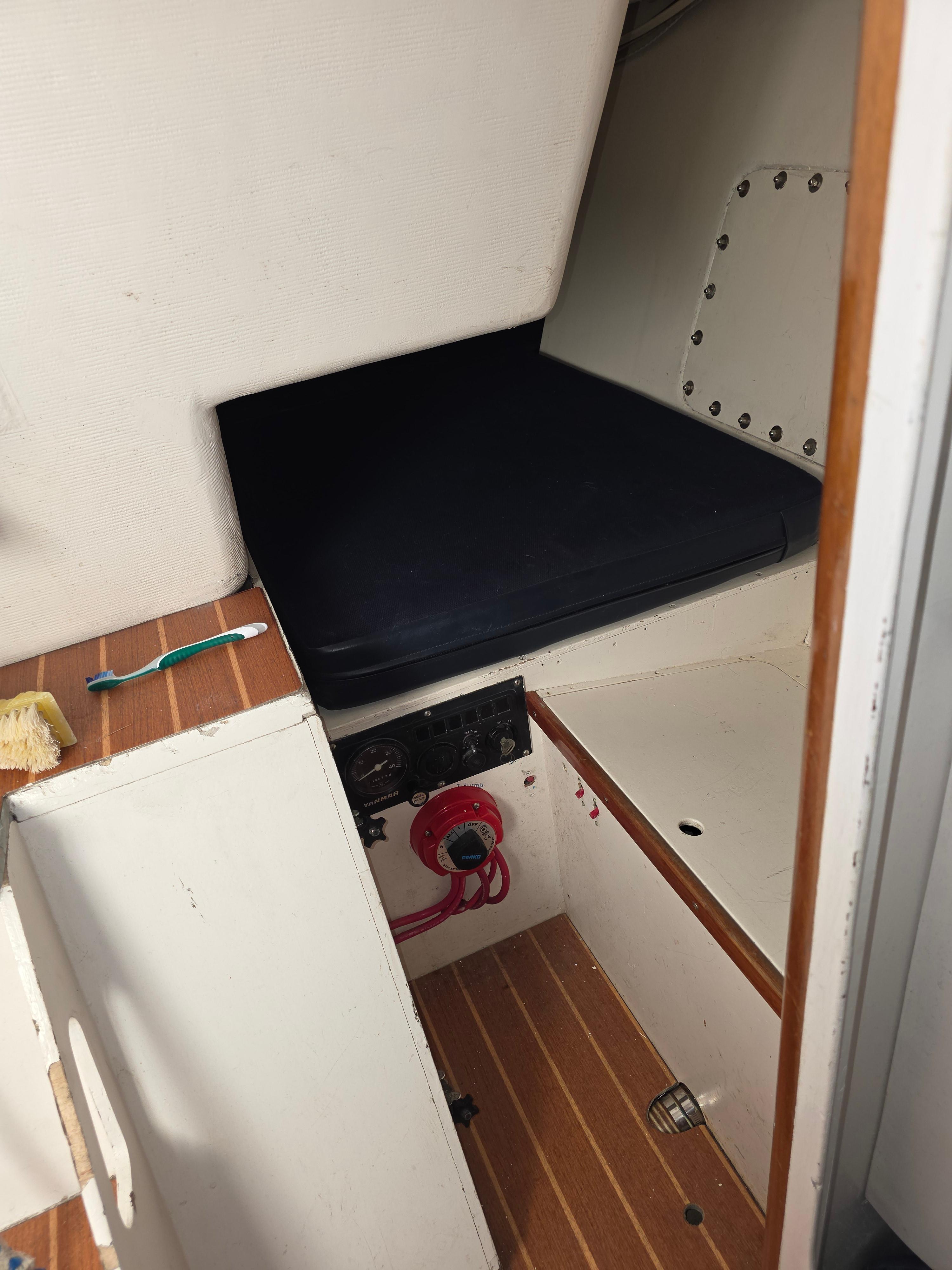 Interior cabin of a 1986 Santa Cruz 50 sailboat with wooden flooring and storage space.