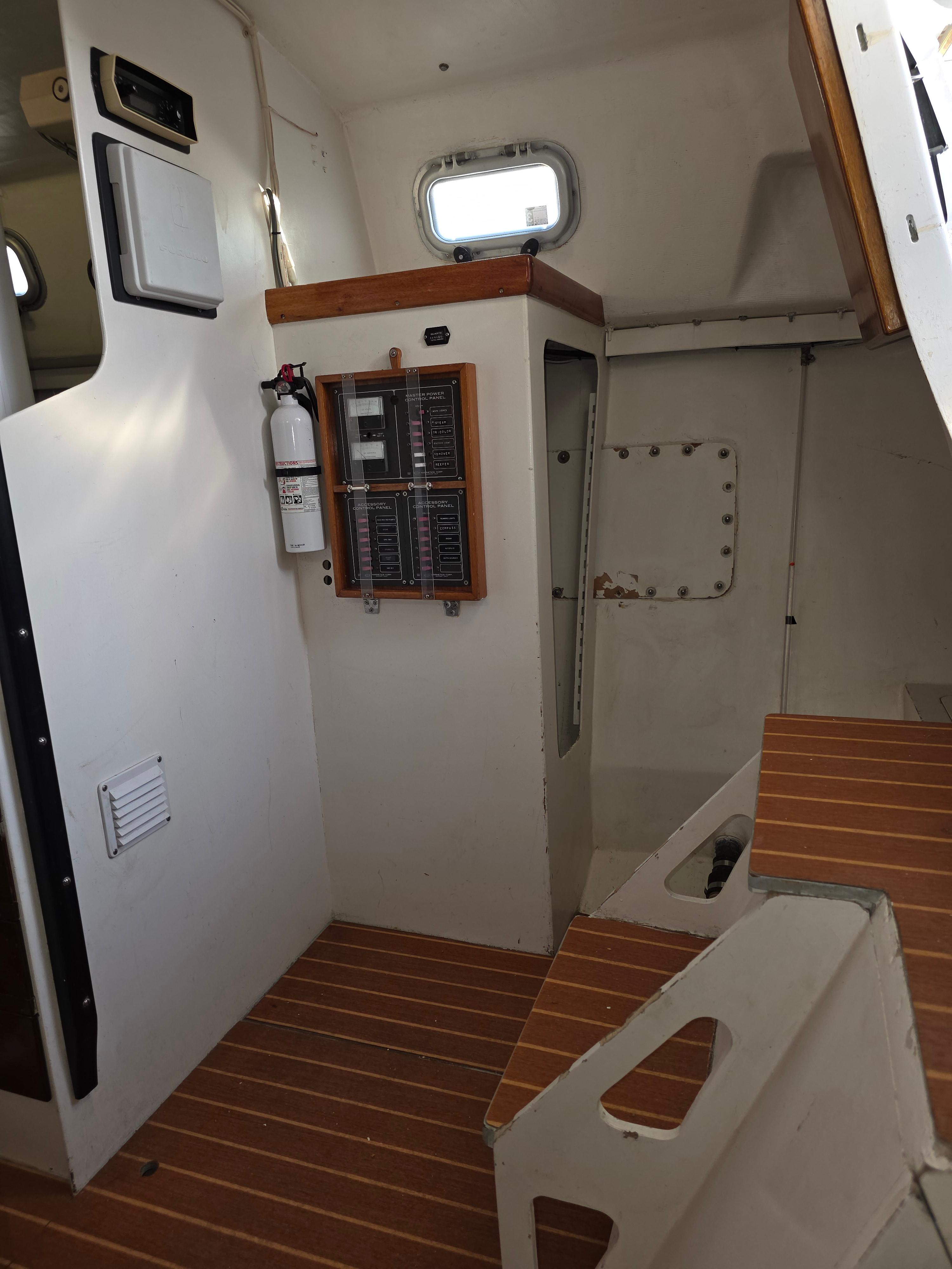 Interior of 1986 Santa Cruz 50 sailboat with wooden flooring and control panel.