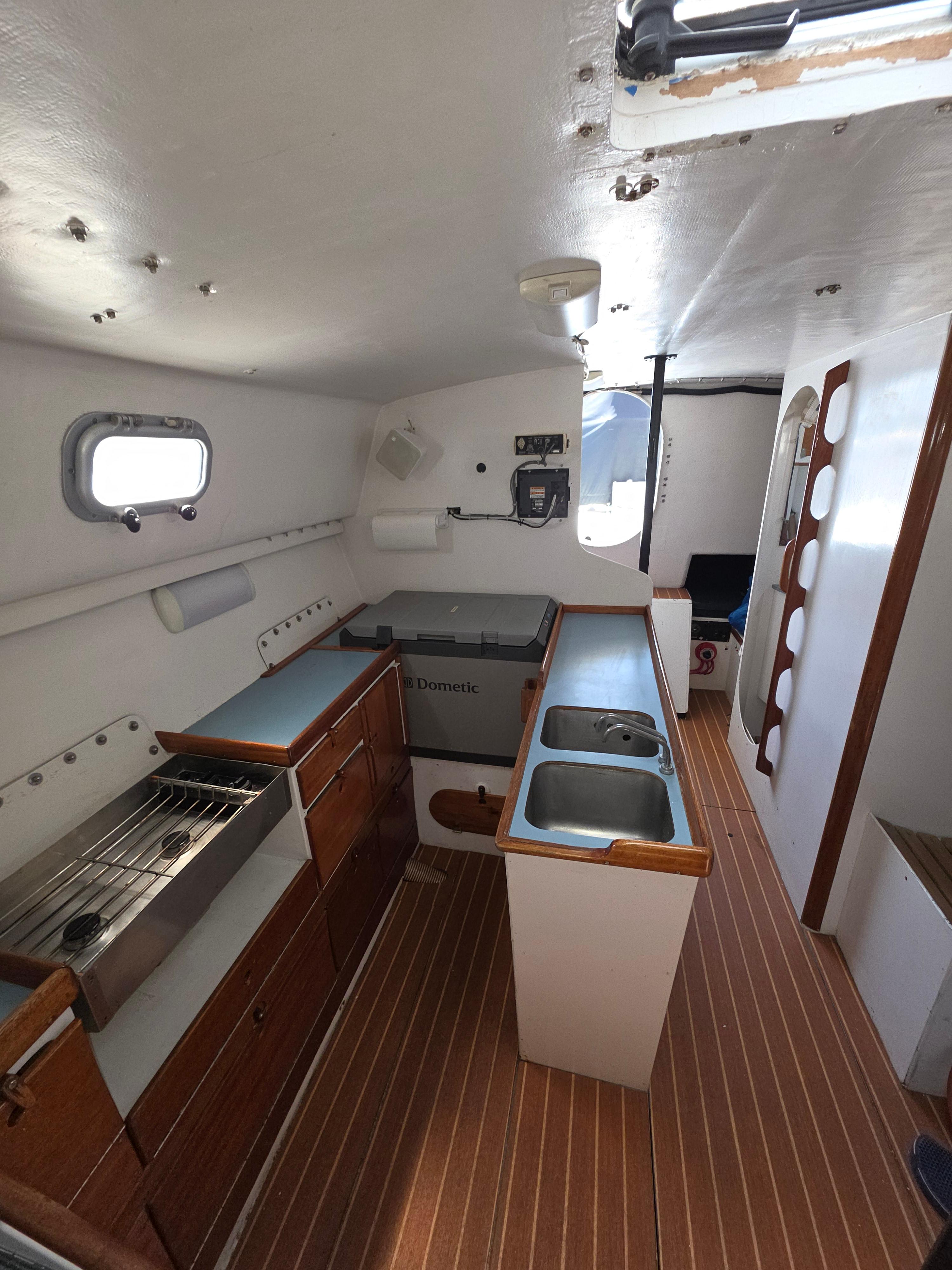 Interior of 1986 Santa Cruz 50 yacht with kitchen and wooden flooring.