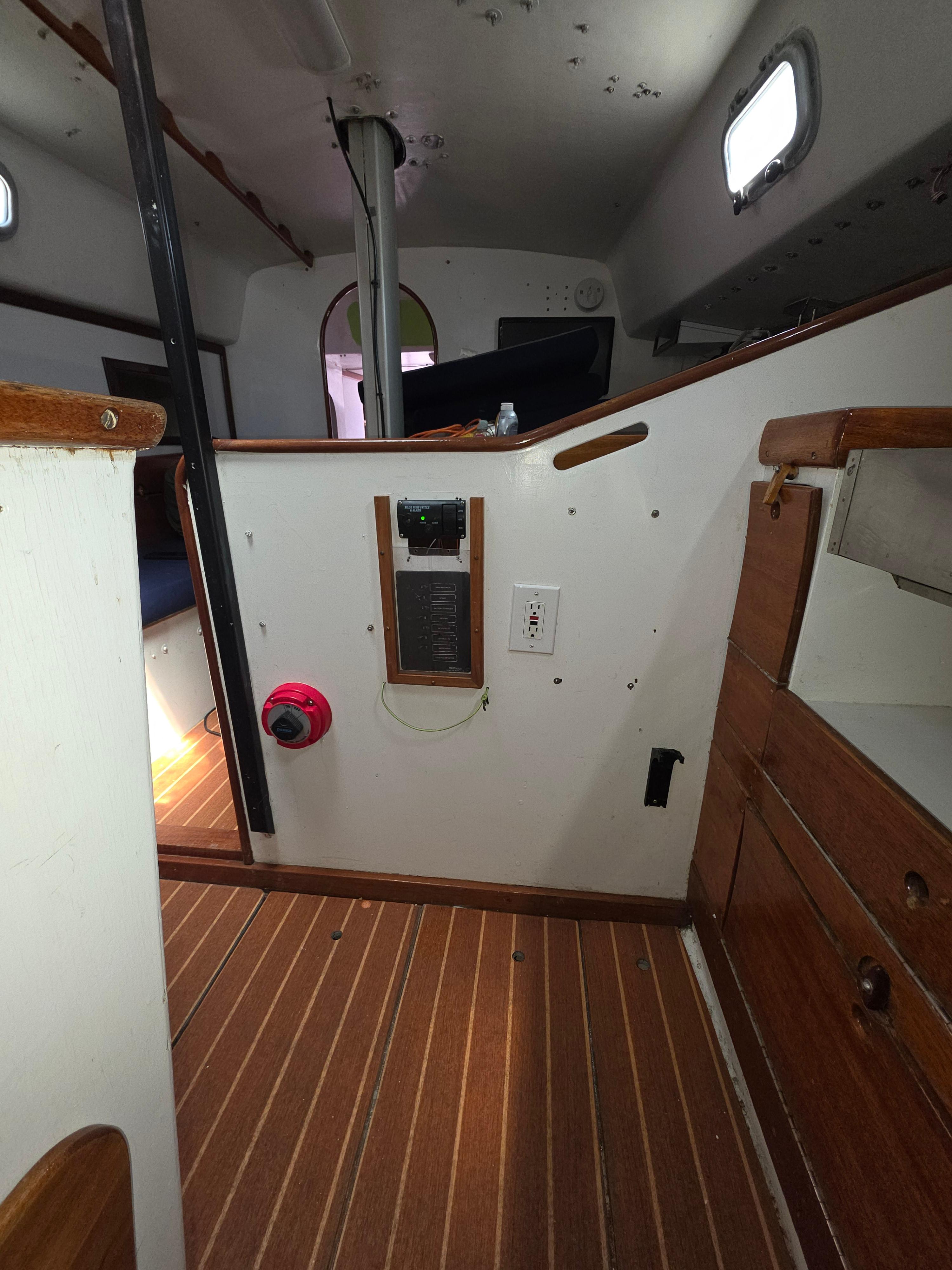 Interior of 1986 Santa Cruz 50 sailboat with wooden flooring and control panel.