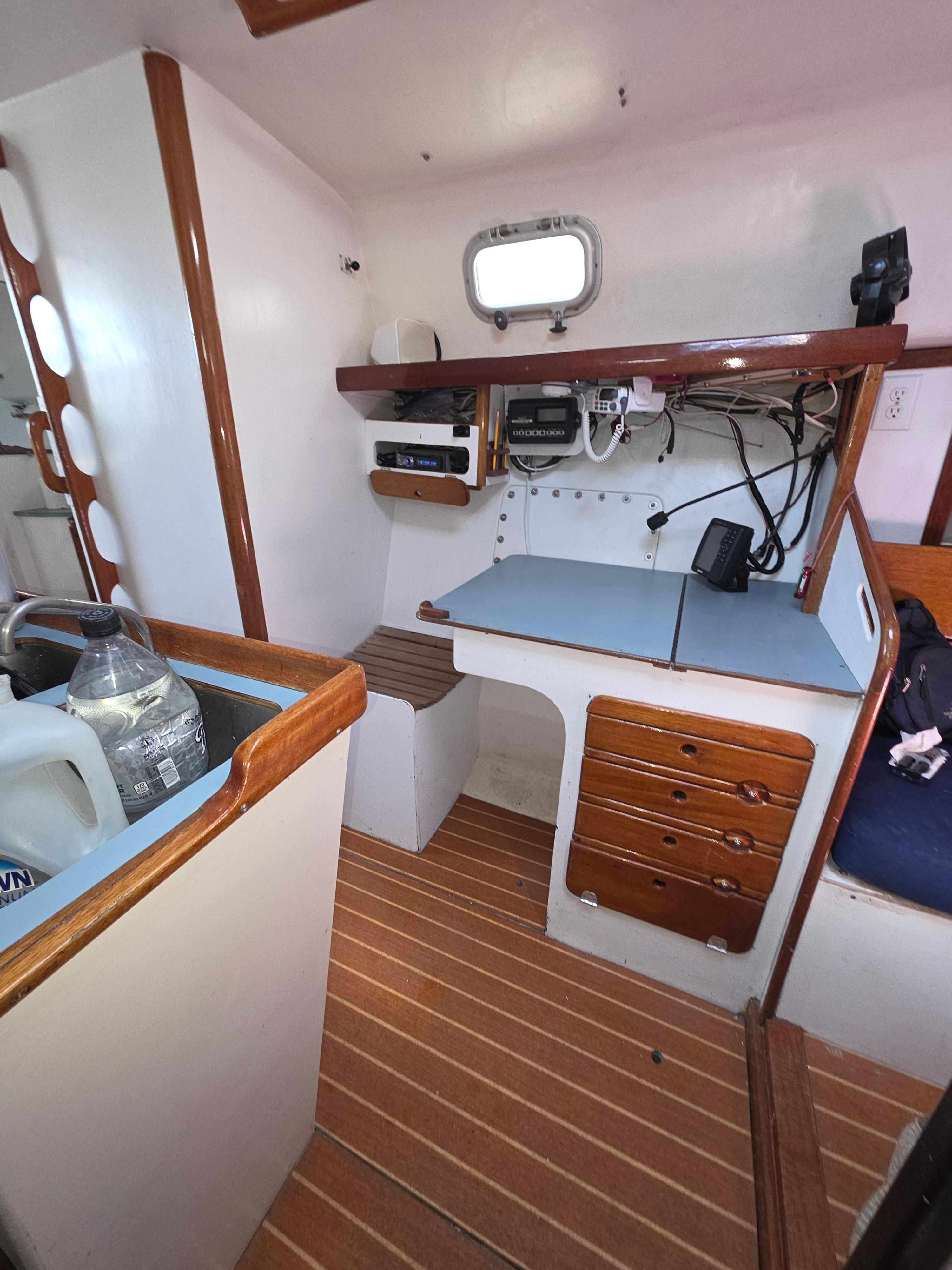 Interior of 1986 Santa Cruz 50 sailboat with navigation station and wooden accents.