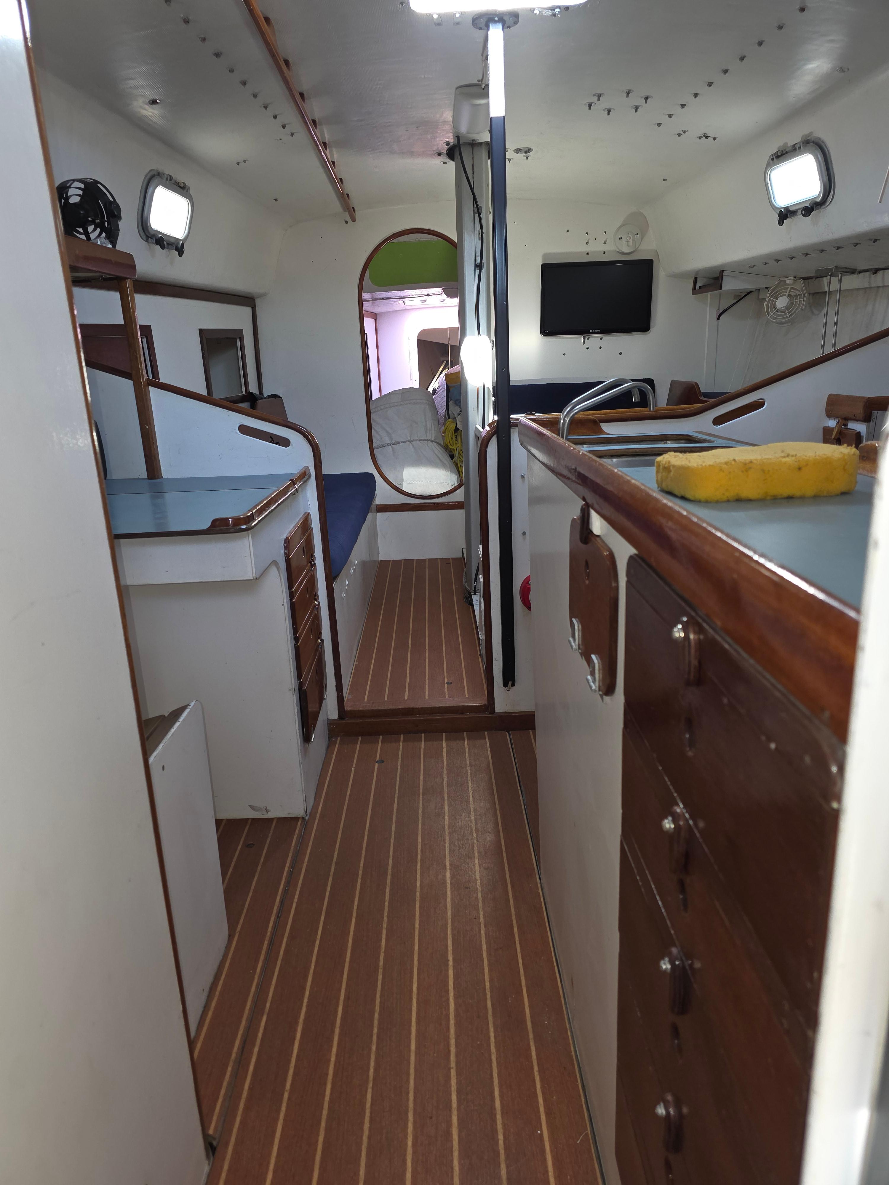 Interior of a 1986 Santa Cruz 50 sailboat with wooden flooring and compact design.