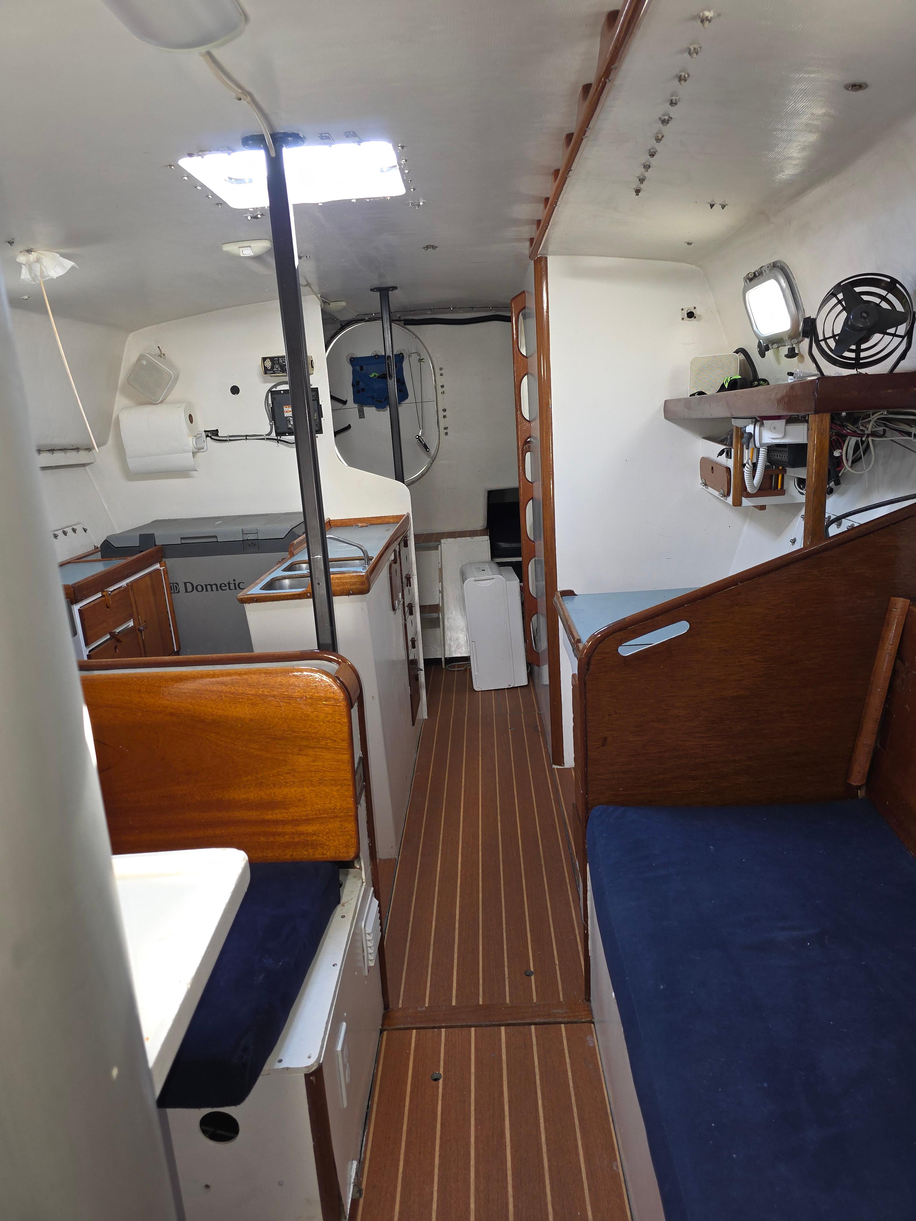 Interior of 1986 Santa Cruz 50 sailboat with wooden finishes and compact layout.