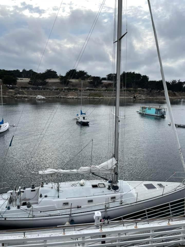 Sailboat docked in a calm harbor under cloudy skies, Santa Cruz 50, 1986 model.