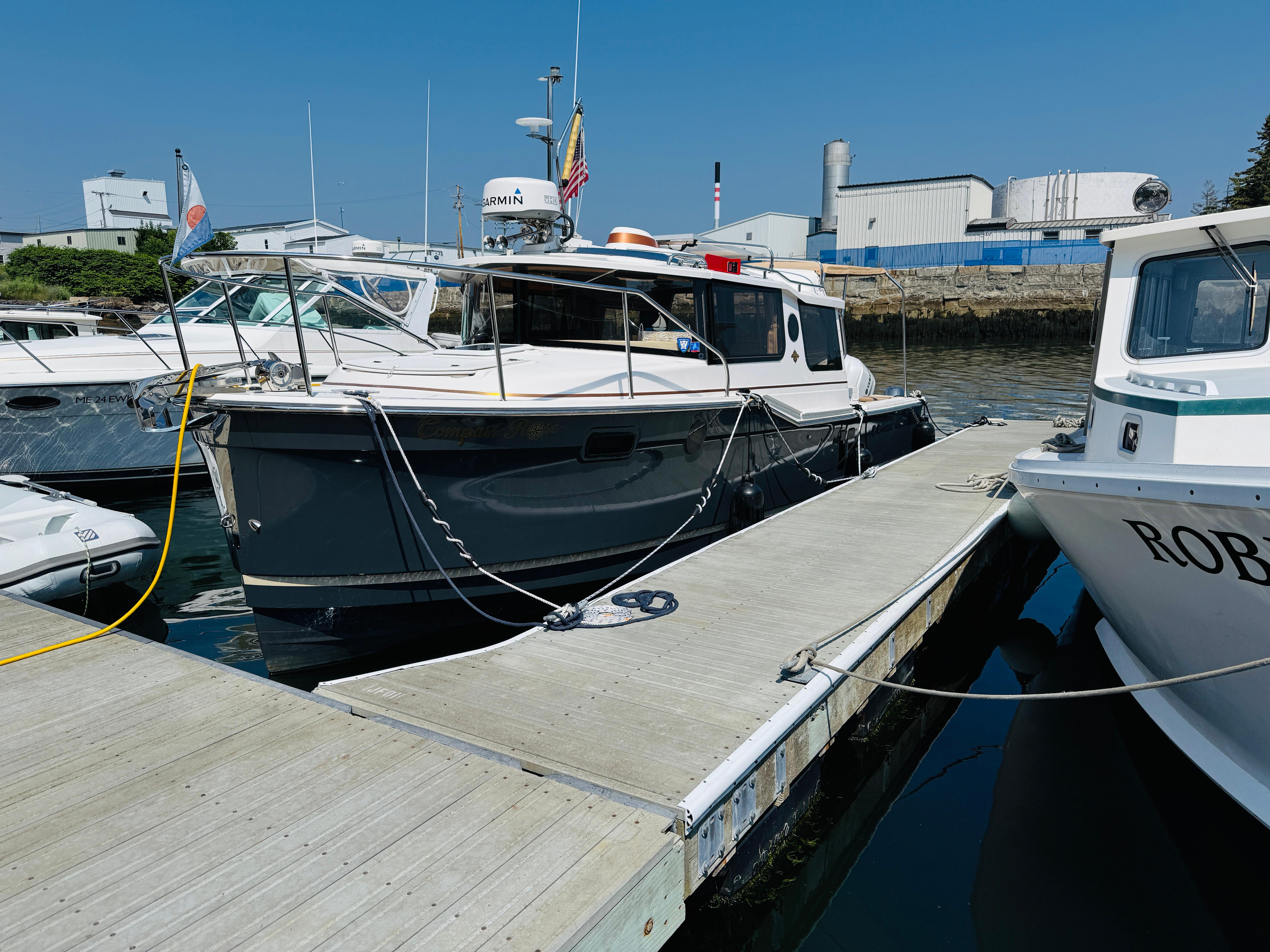 2018 Ranger Tugs R-27 docked at a marina under clear blue skies.