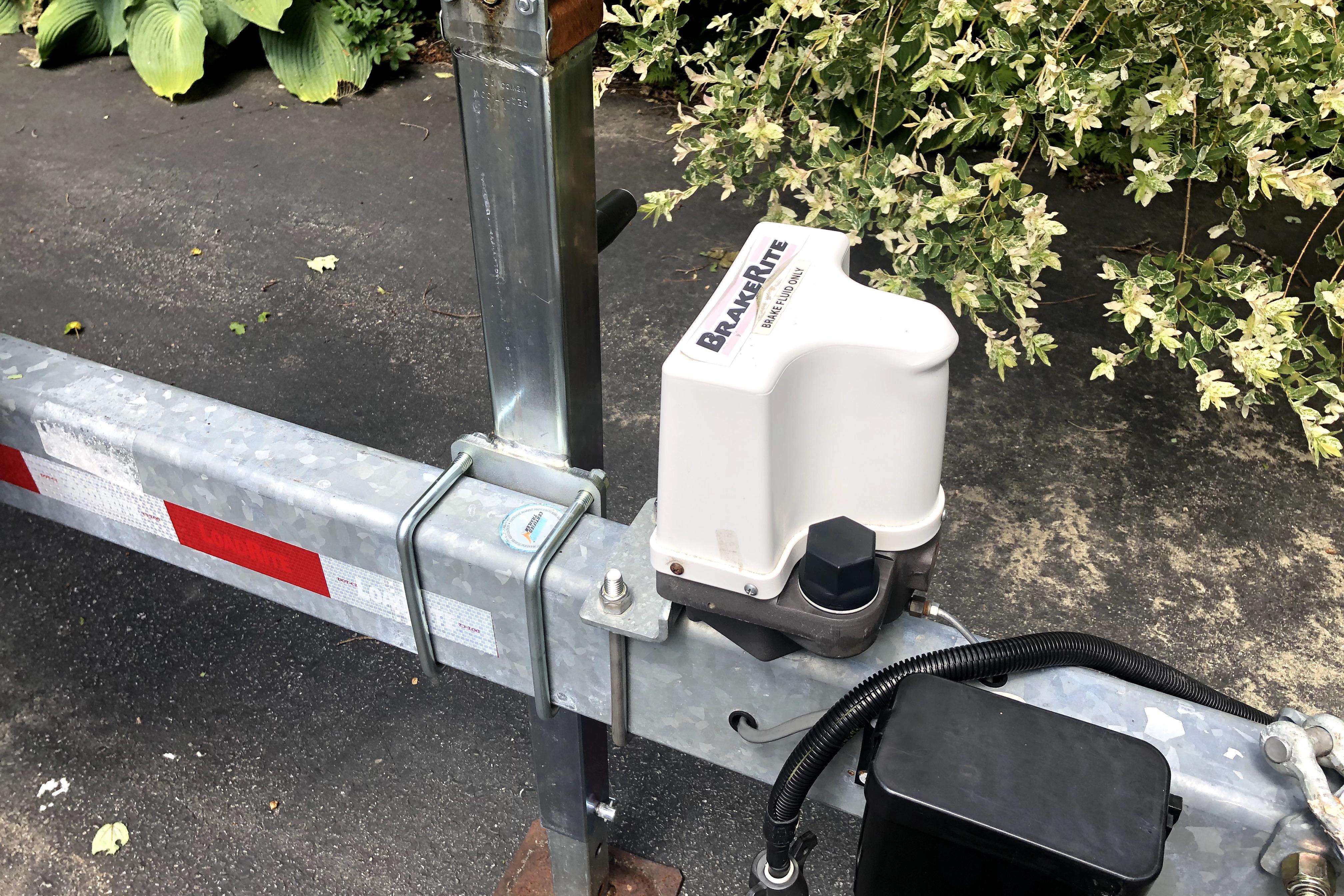 Trailer brake actuator on a Ranger Tugs R-27, 2018 model, parked on asphalt.