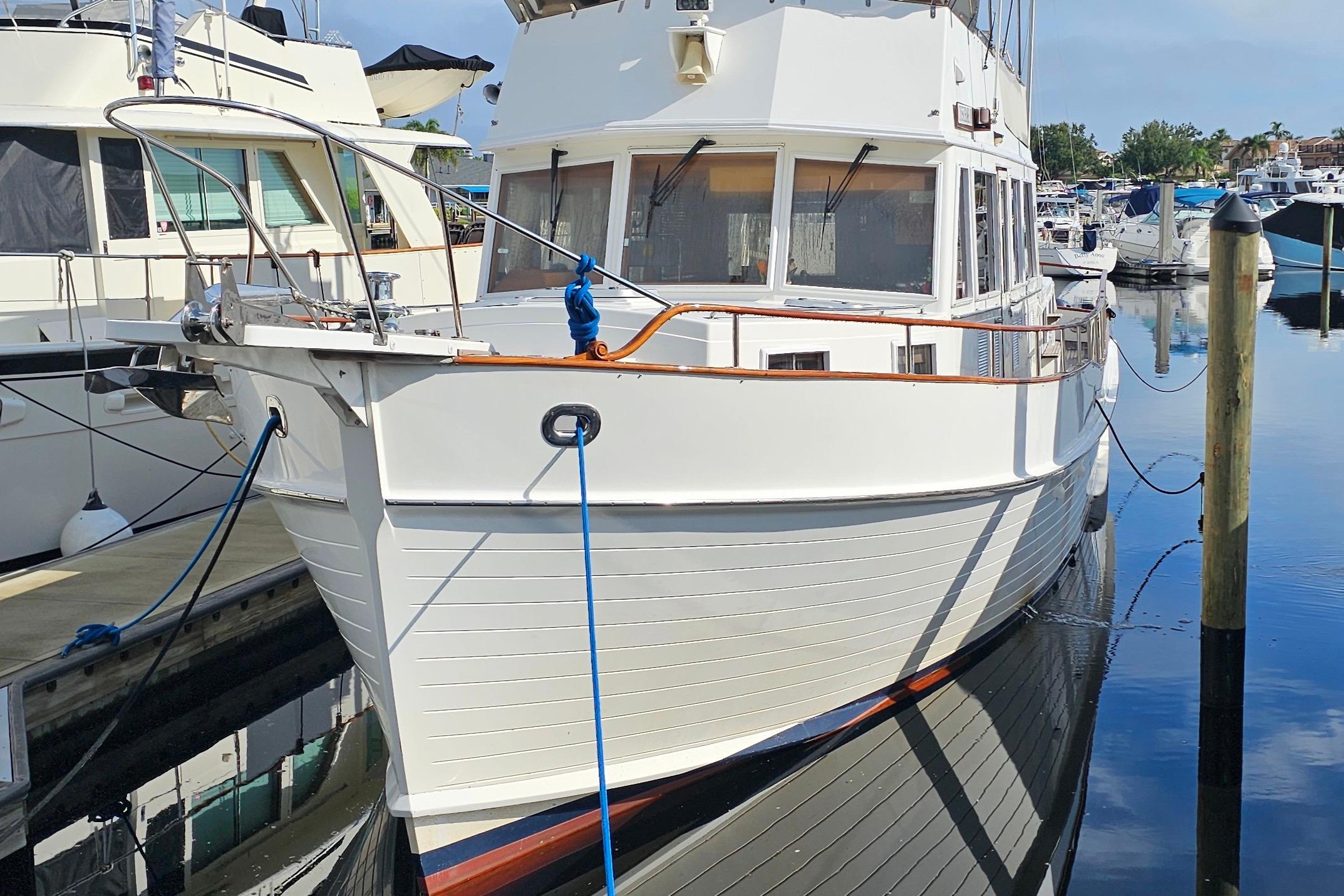 1997 Grand Banks 49 Classic yacht docked in a marina, reflecting on calm water.