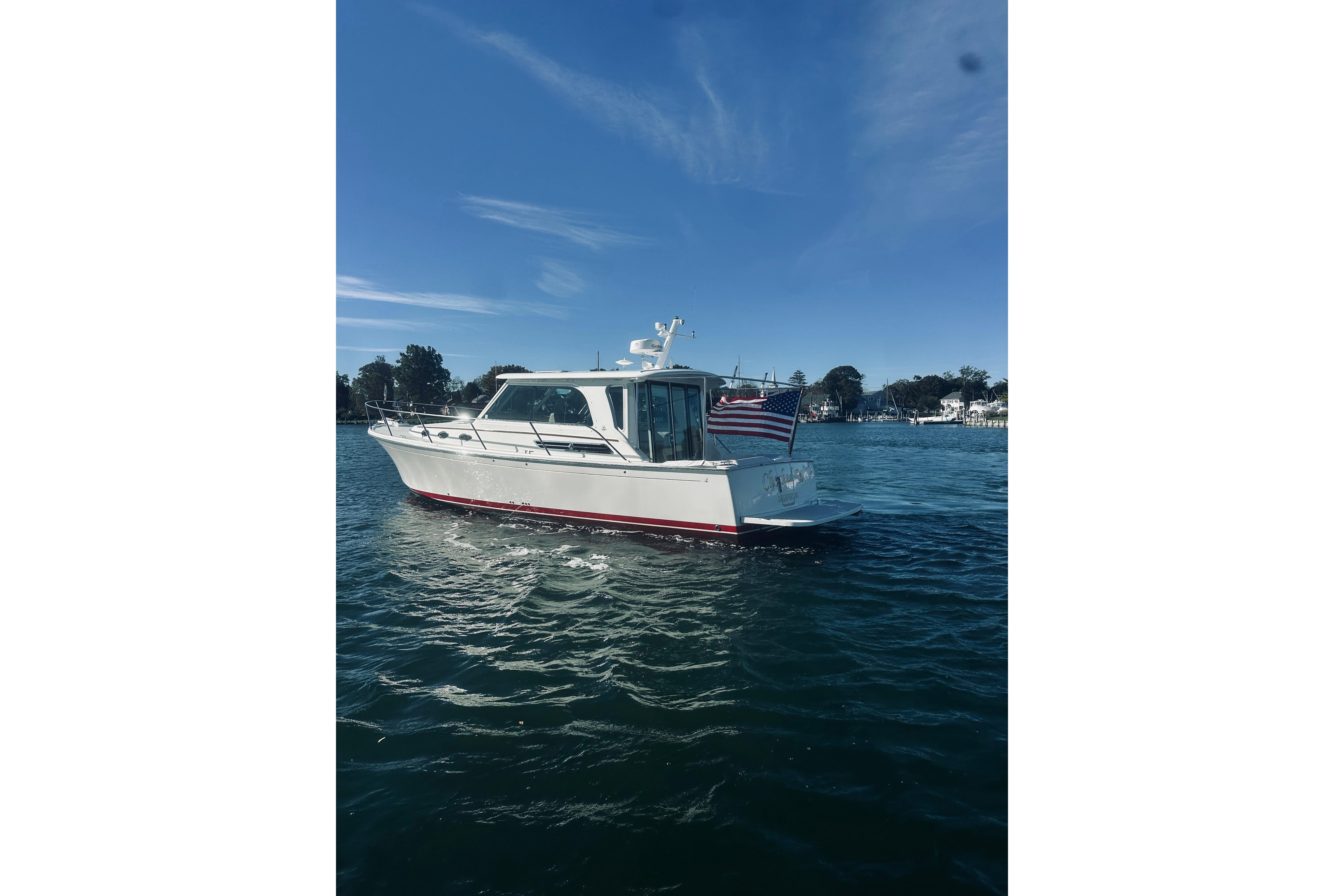 2021 Back Cove 37 boat on water with American flag, clear sky background.