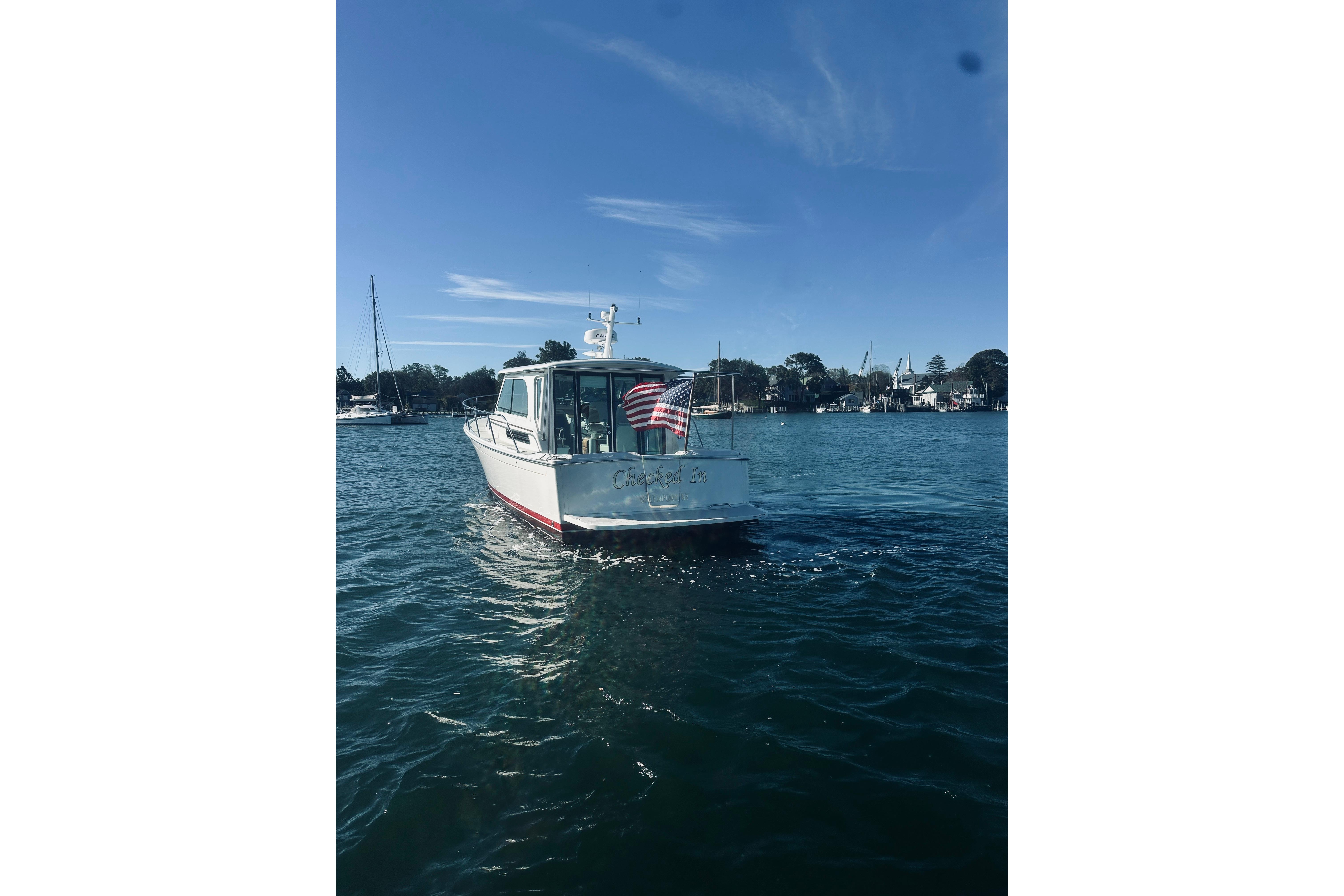2021 Back Cove 37 boat on calm water with American flag, clear sky background.