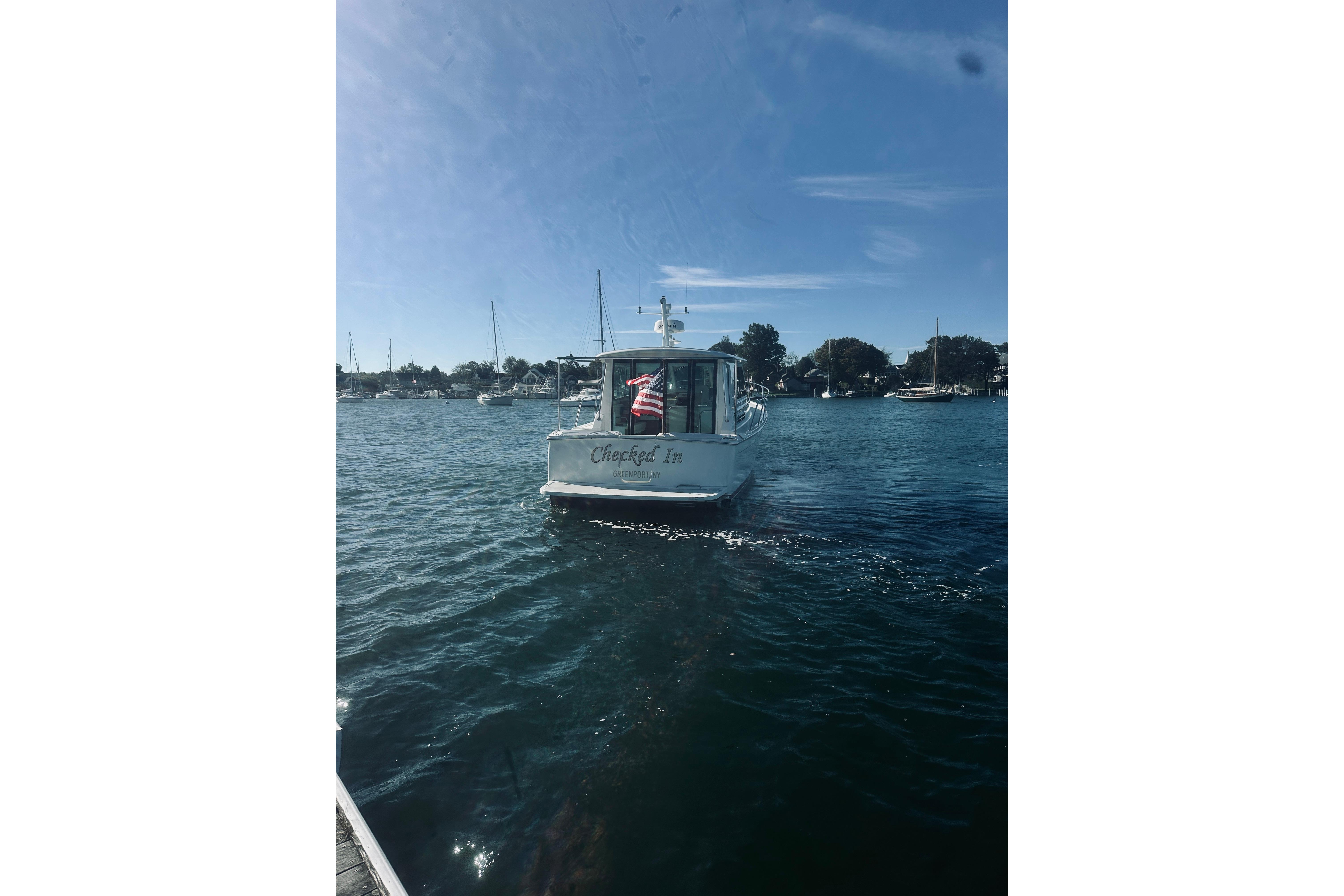 2021 Back Cove 37 boat on water with American flag, clear sky, and marina background.