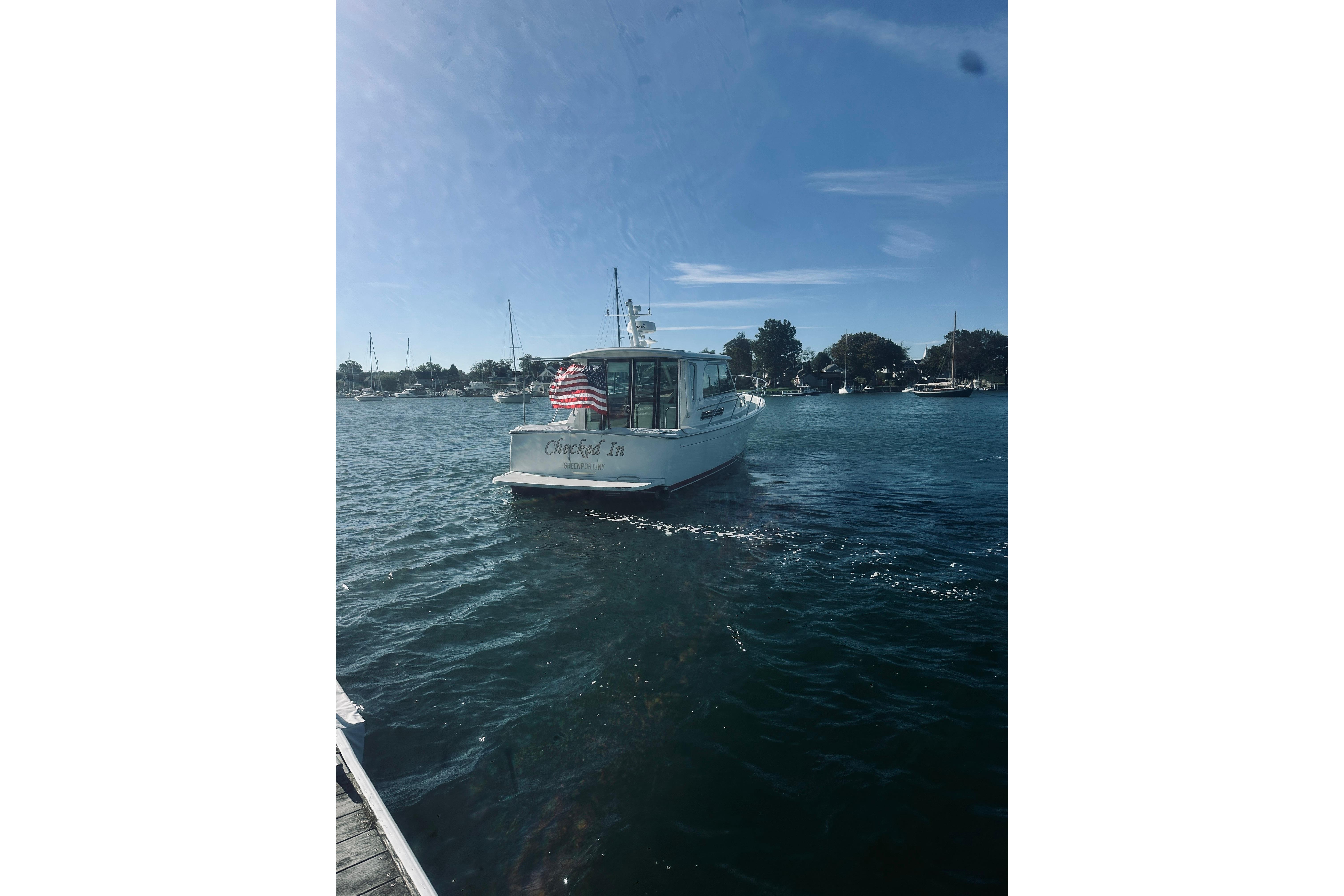 Back Cove 37 boat from 2021 on water, American flag displayed, clear sky.