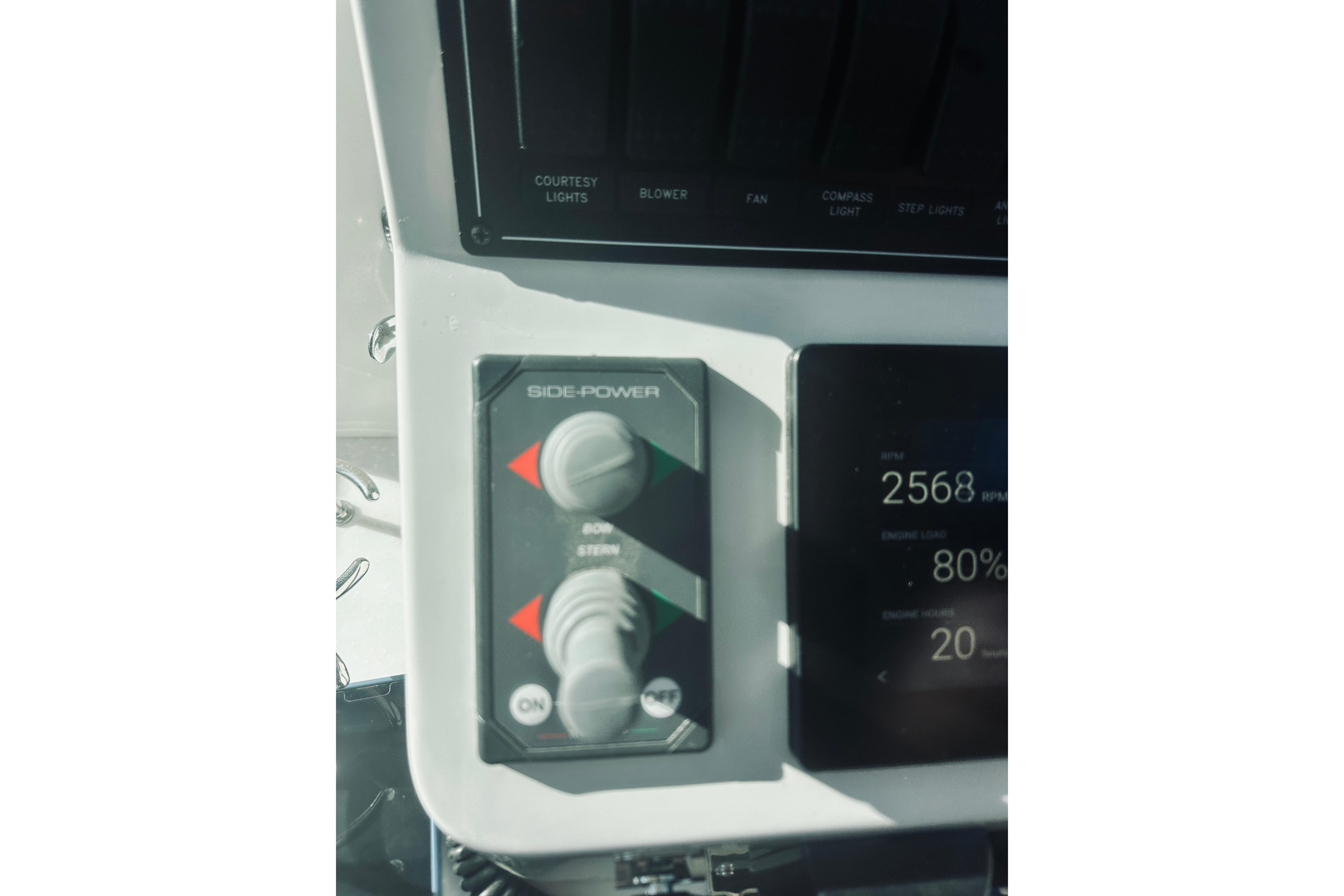 Control panel of a 2021 Back Cove 37 boat, featuring Side-Power controls and digital display.