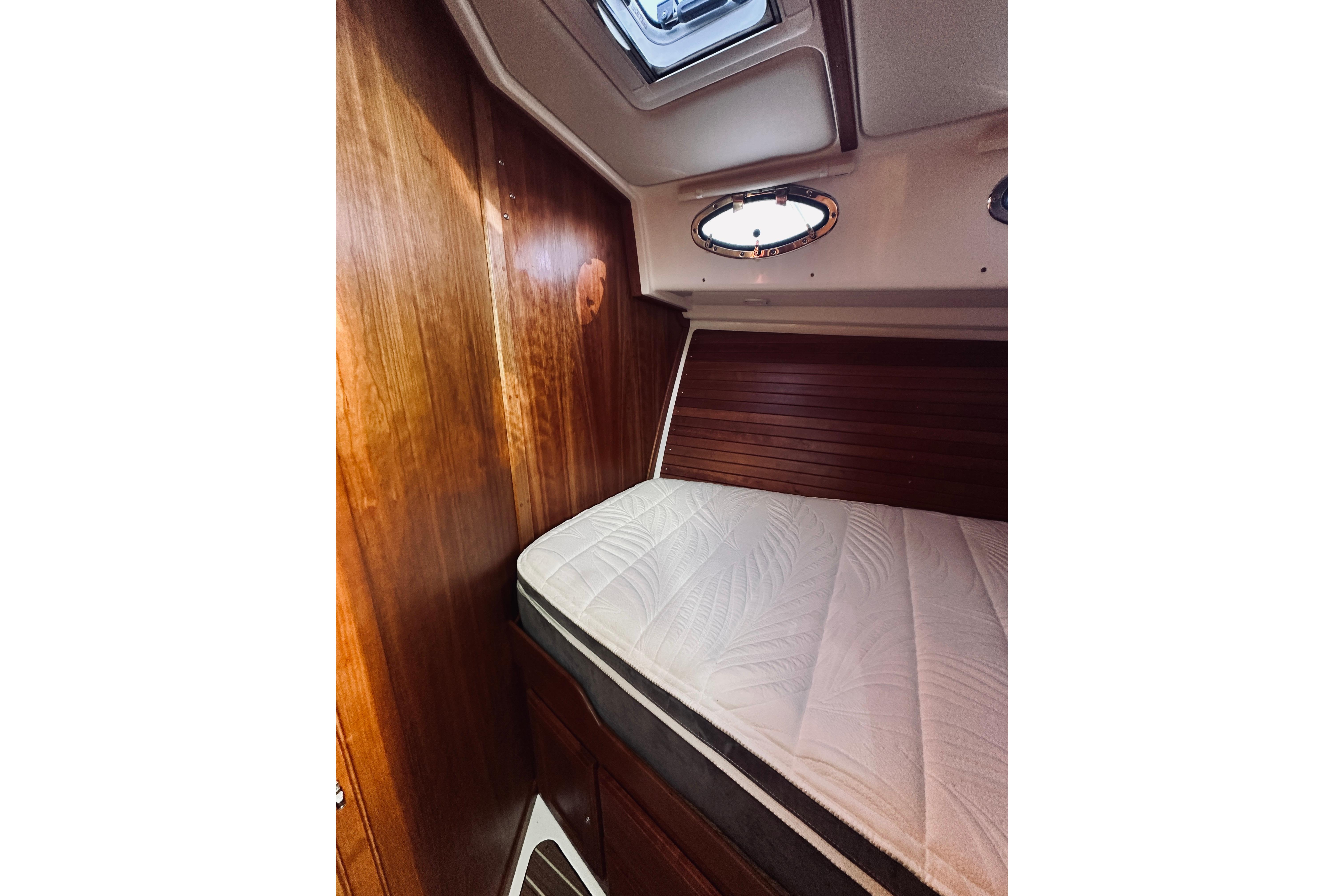 2021 Back Cove 37 cabin interior with wooden paneling and a comfortable bed.