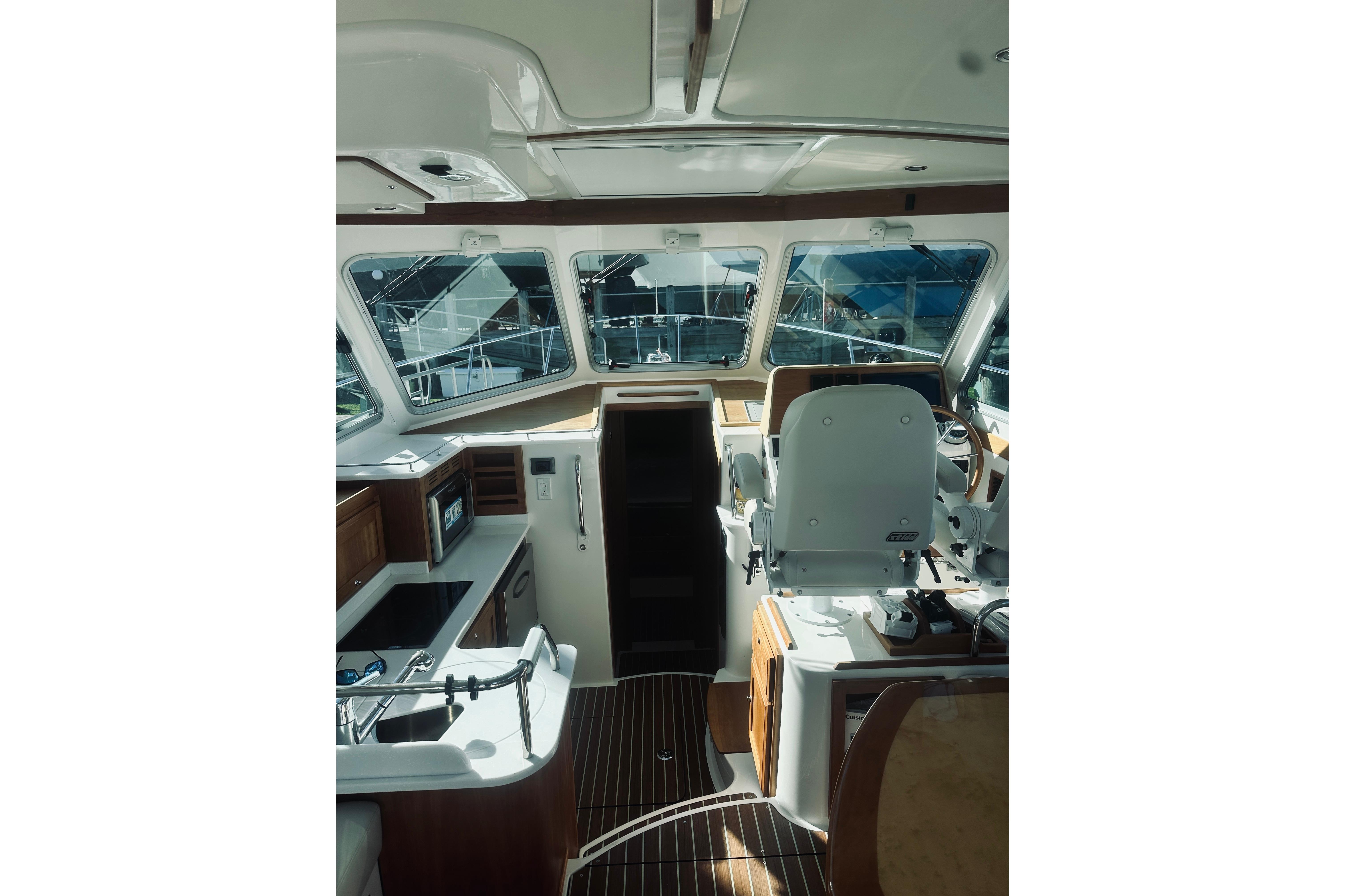 Interior of 2021 Back Cove 37 yacht, featuring helm and galley area with modern amenities.