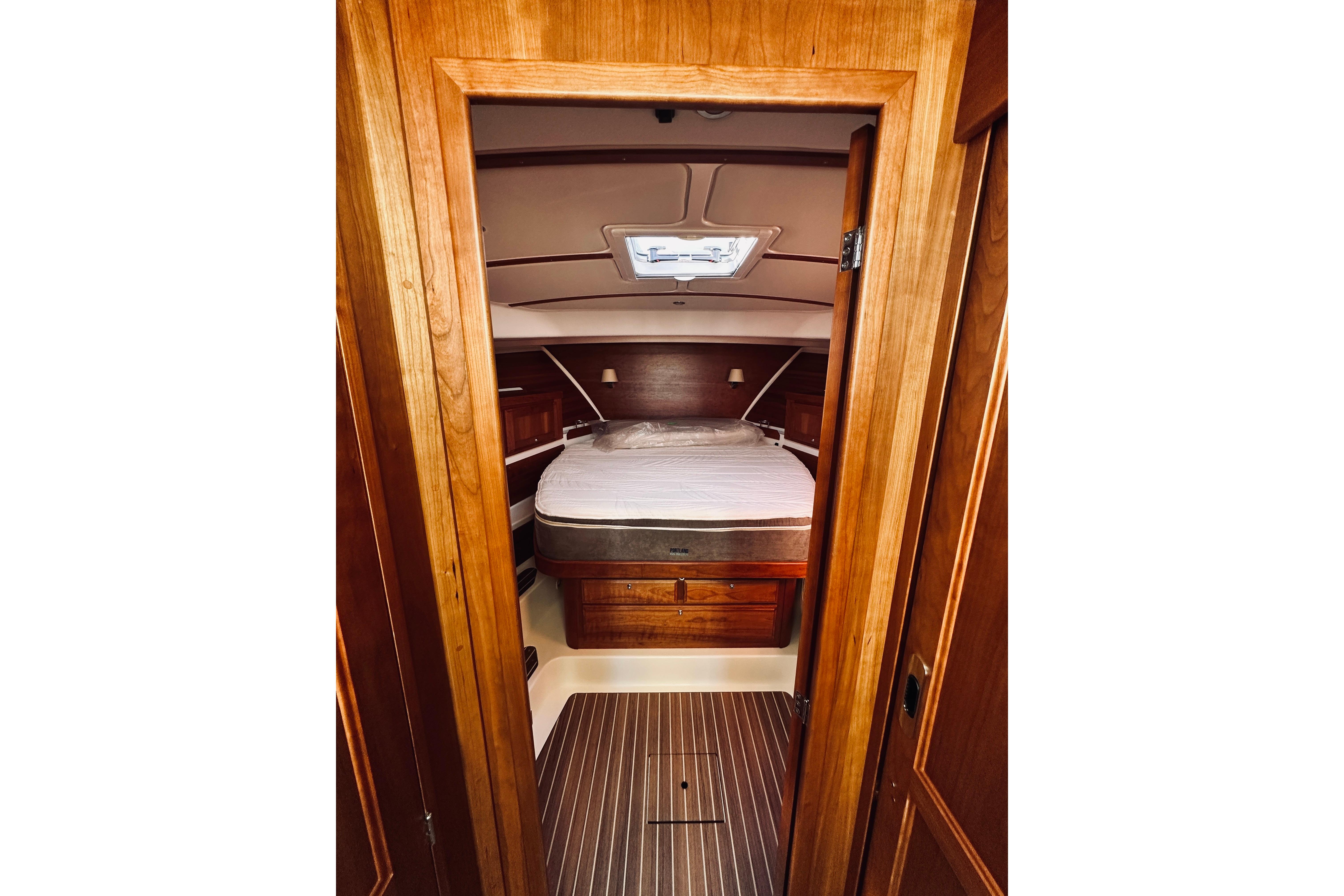Cozy cabin interior of 2021 Back Cove 37 yacht with wooden finish and bed.