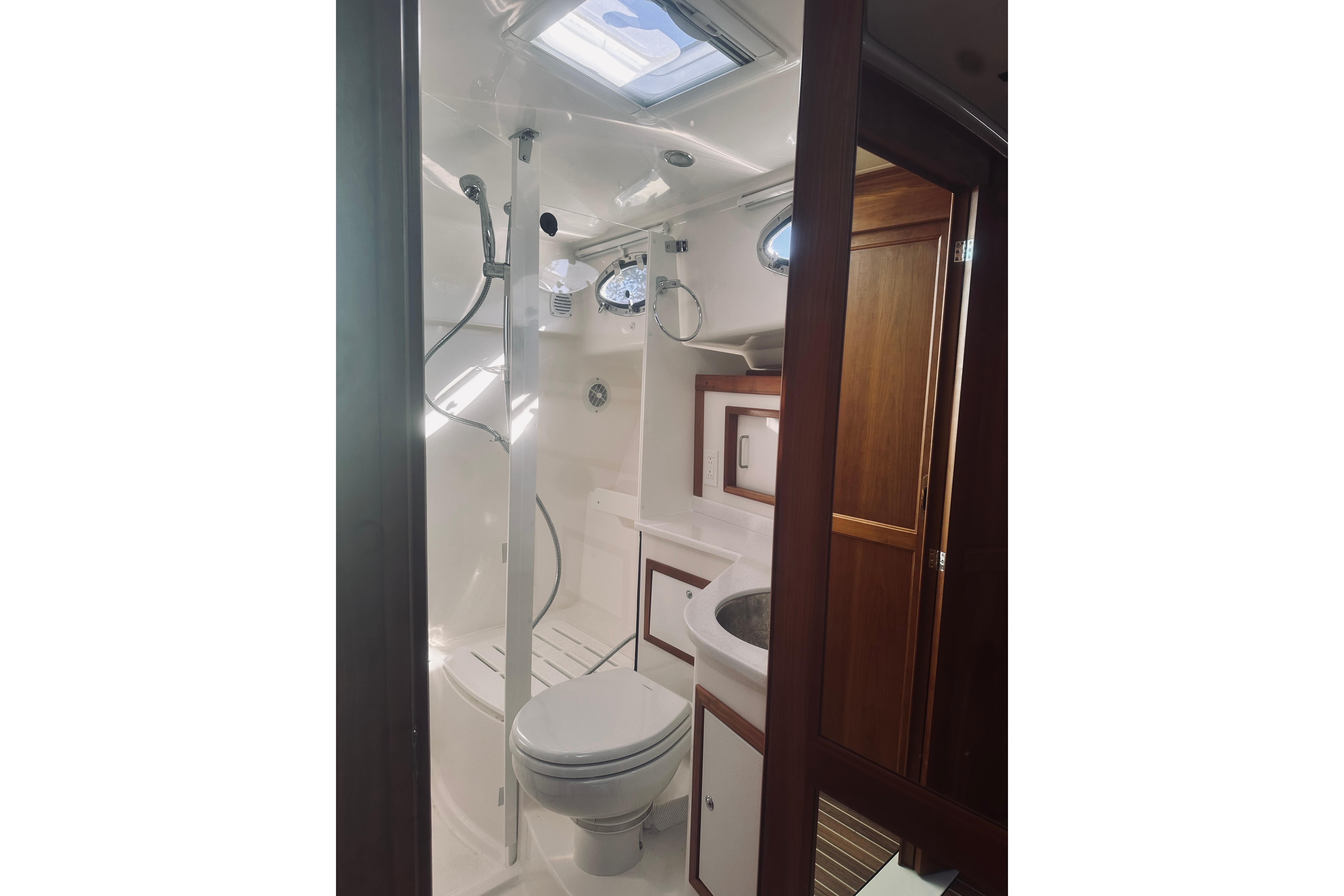 Luxurious bathroom in 2021 Back Cove 37 yacht with shower and wooden cabinetry.
