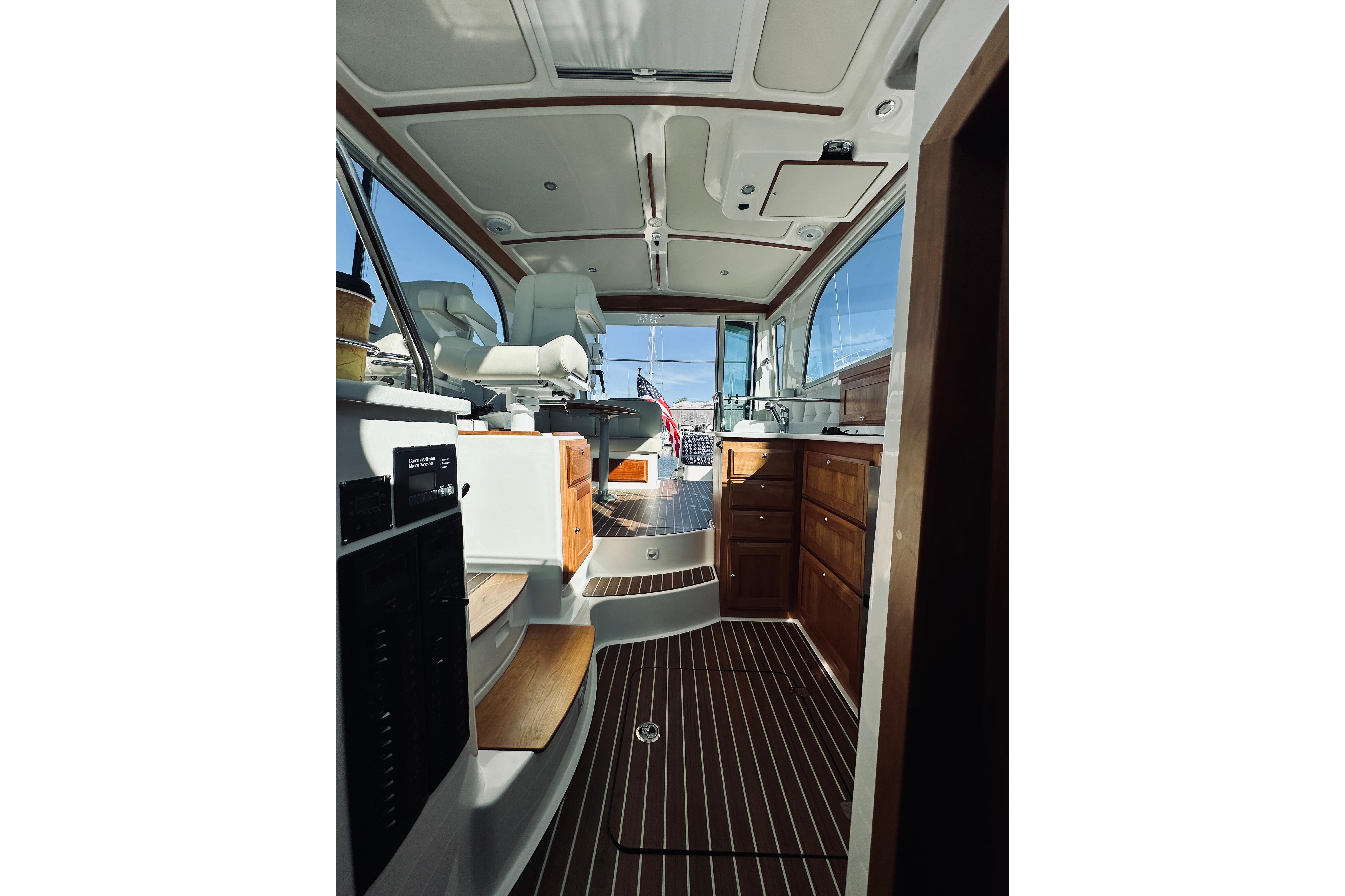 Interior of 2021 Back Cove 37 yacht, featuring elegant wood cabinetry and modern seating.