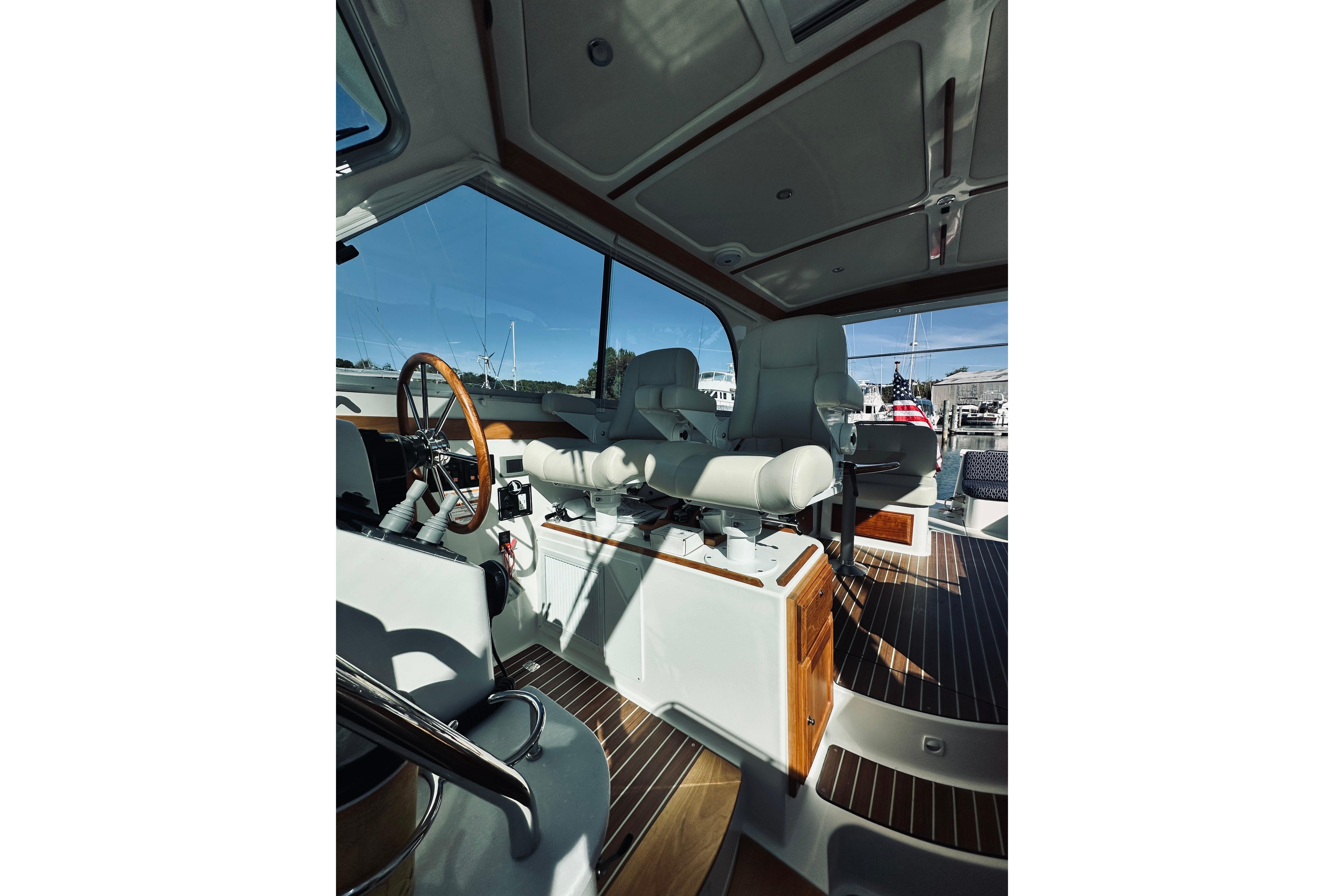 Interior of 2021 Back Cove 37 yacht, featuring helm station and luxurious seating.