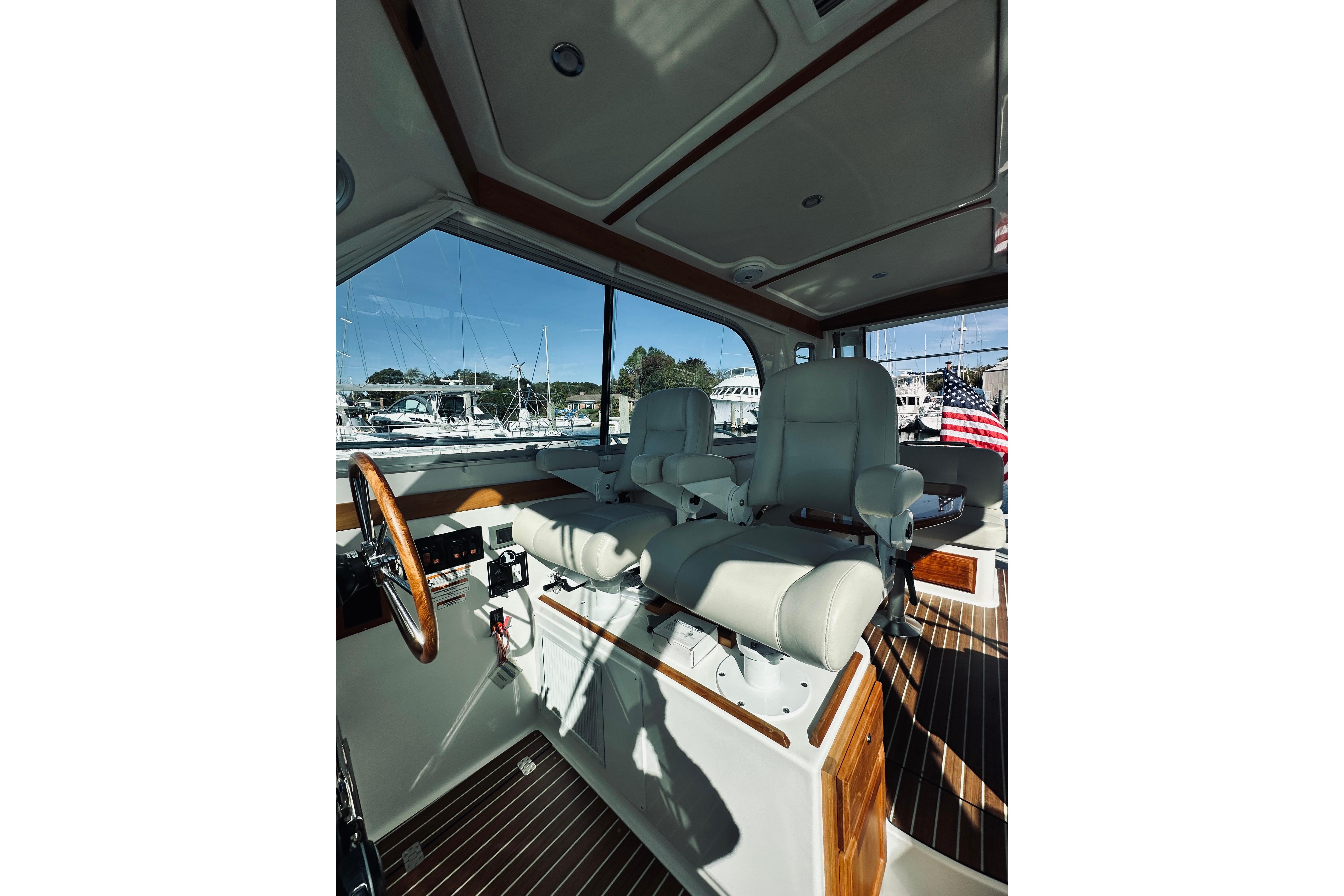 Interior of 2021 Back Cove 37 boat with helm seats and wooden accents.