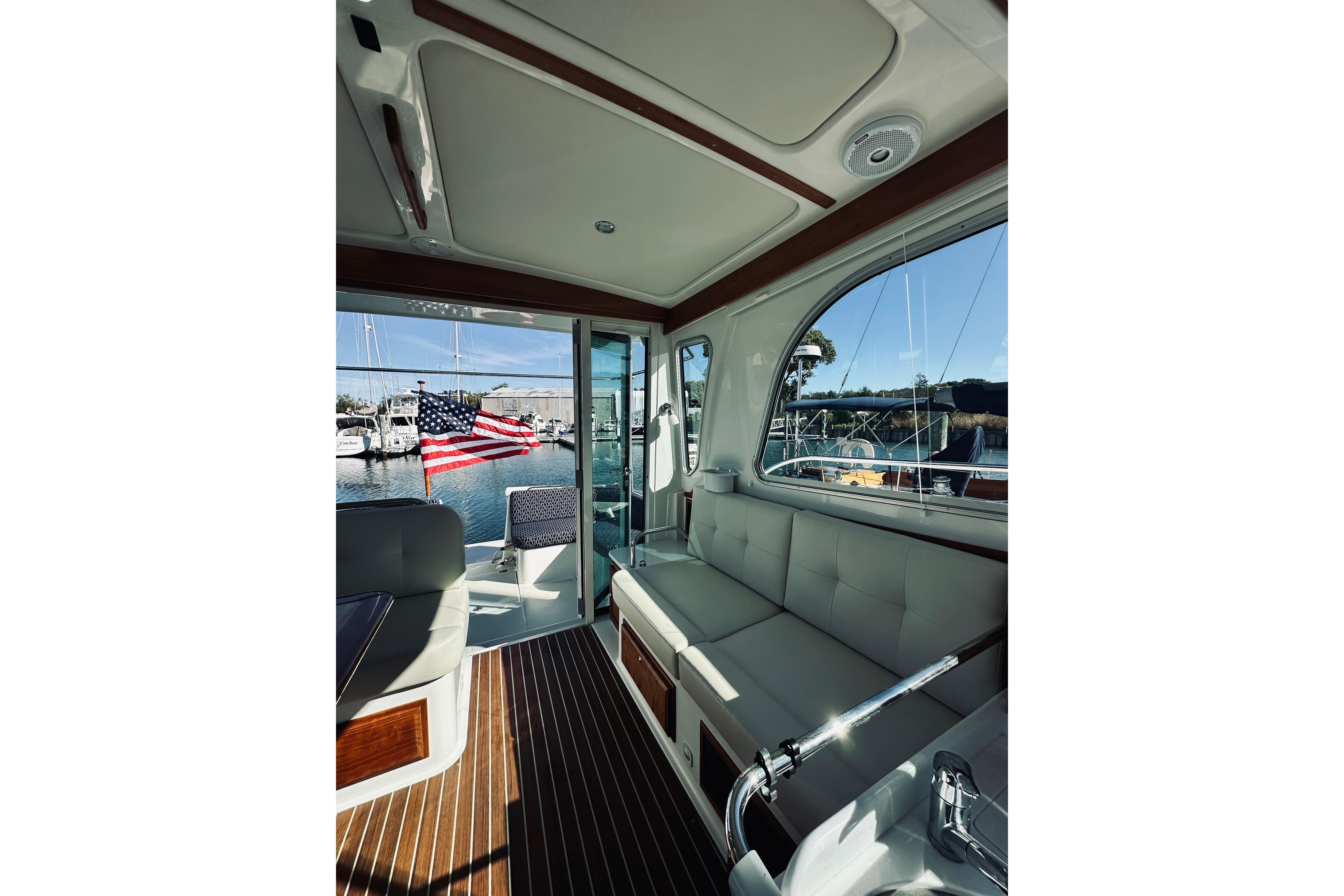 Interior view of 2021 Back Cove 37 yacht with American flag and marina backdrop.