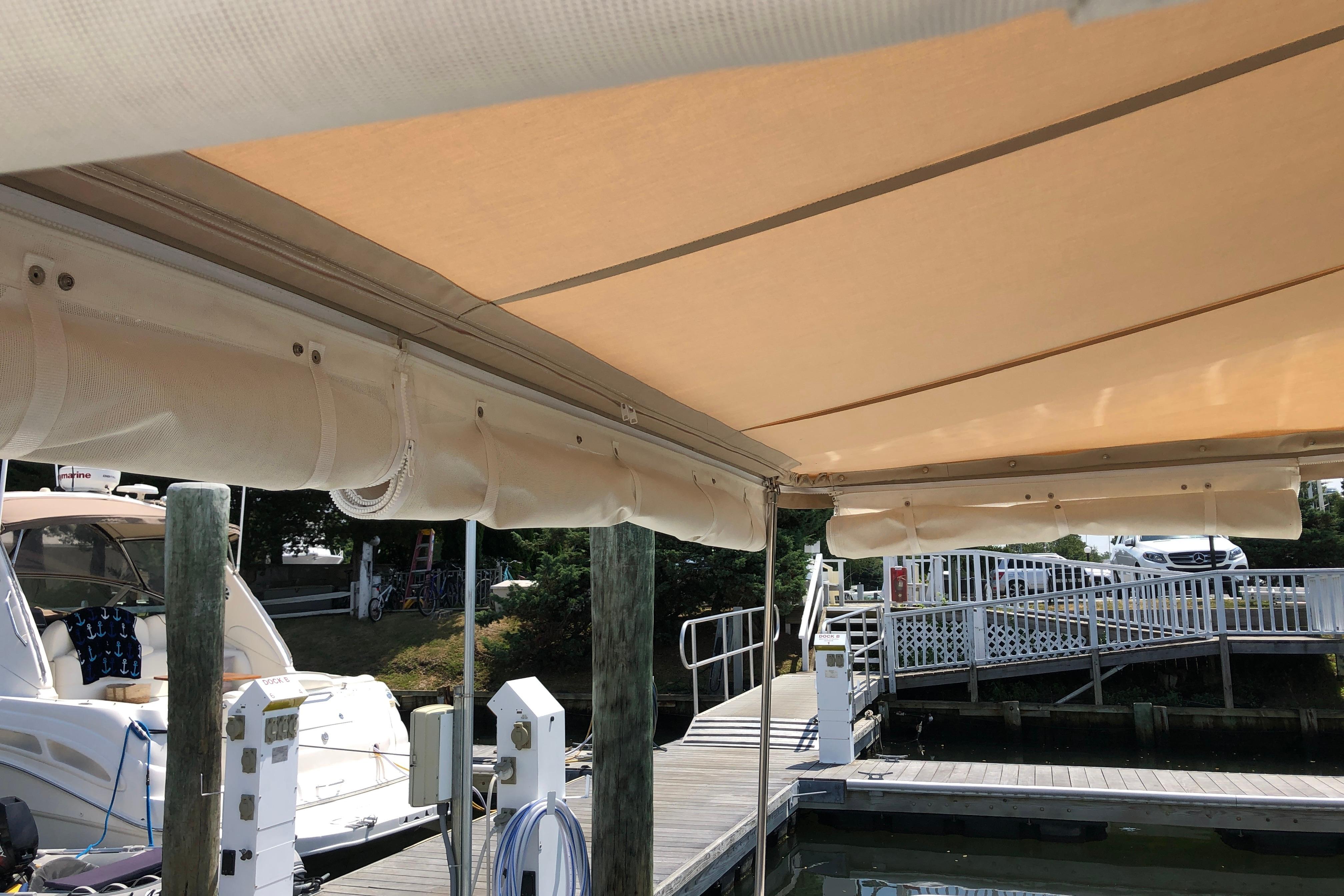 Boat docked under canopy at marina, featuring 2021 Back Cove 37 model.