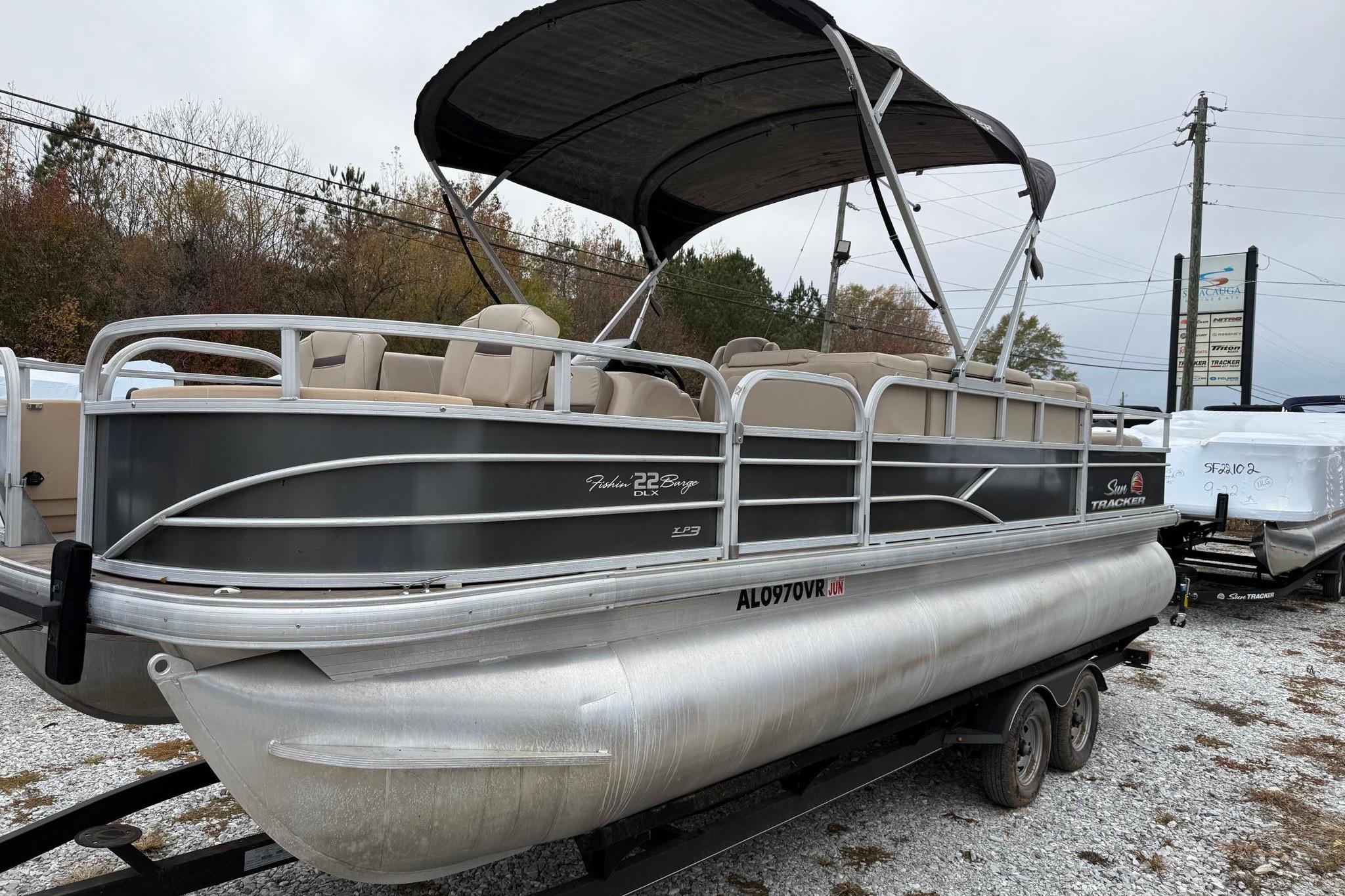 2019 Sun Tracker Fishin' Barge 22 XP3 pontoon boat on a trailer, parked outdoors.