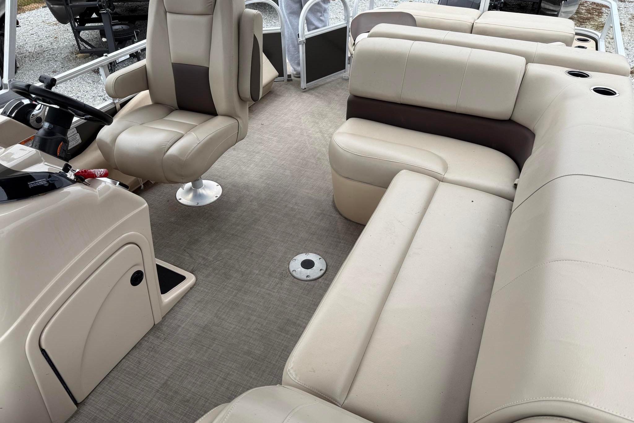 2019 Sun Tracker Fishin' Barge 22 XP3 interior with beige seating and steering console.