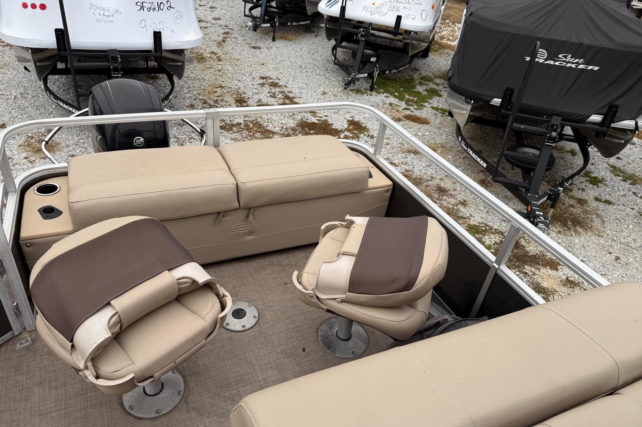 2019 Sun Tracker Fishin' Barge 22 XP3 interior with beige seating and fishing chairs.