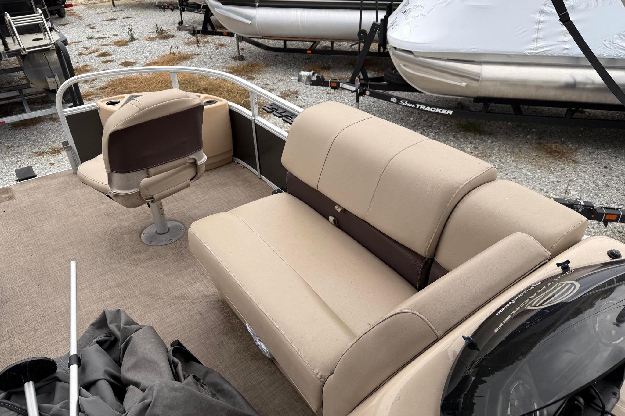 2019 Sun Tracker Fishin' Barge 22 XP3 interior with beige seating and fishing chair.