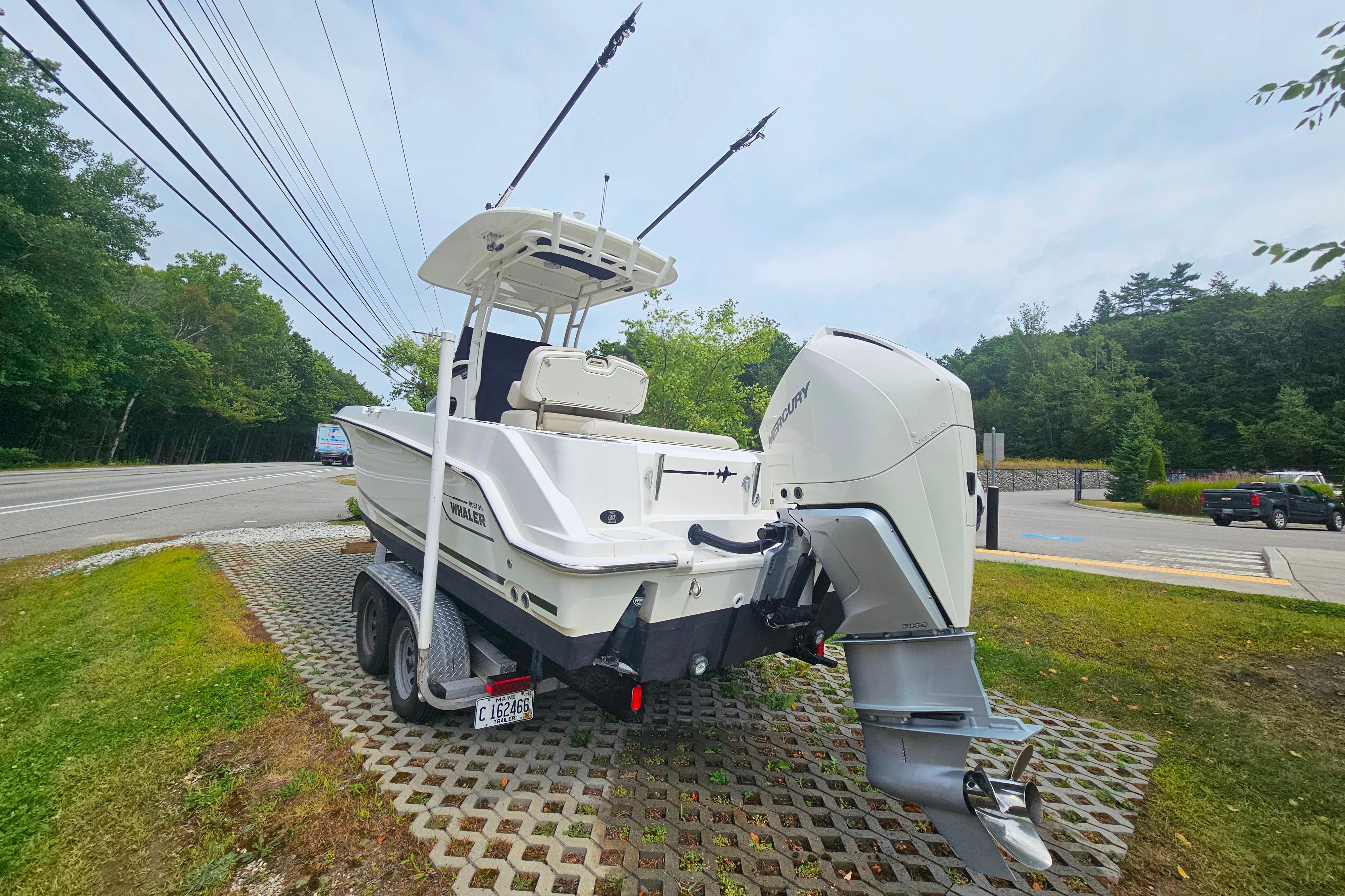 2019 Boston Whaler 230 Outrage boat on trailer, parked near a road.