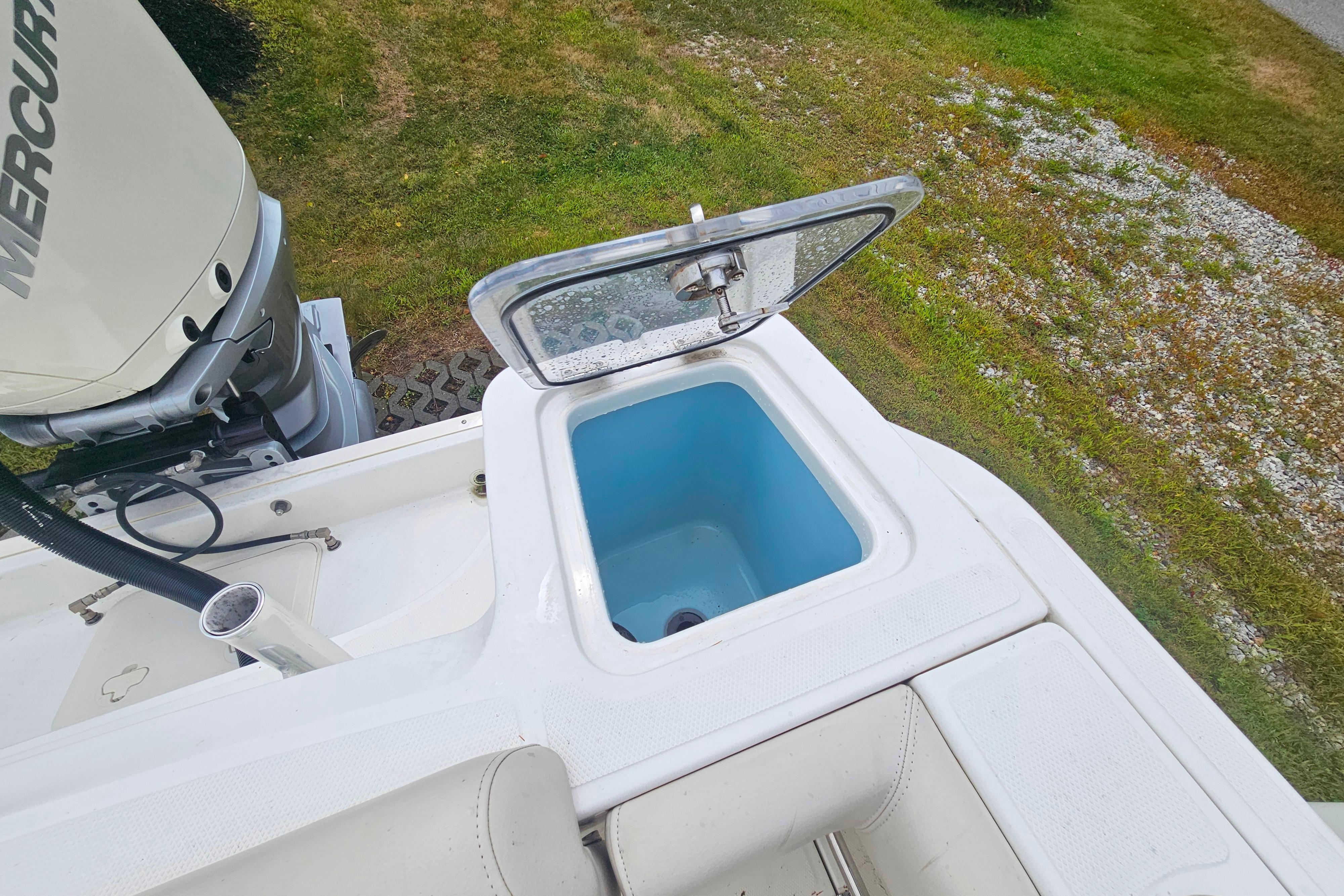 2019 Boston Whaler 230 Outrage boat with open storage compartment and Mercury engine.